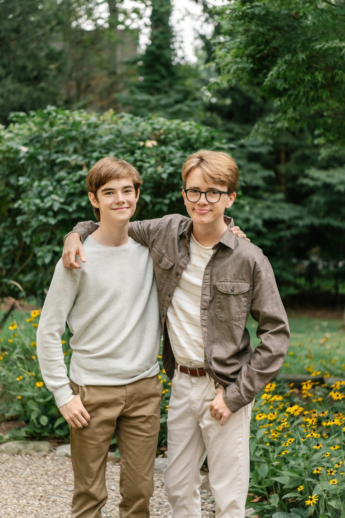  Two brothers with their arms around each other in a green backyard in New Jersey by Nicole Hawkins Photography. brother portrait #NicoleHawkinsPhotography #NicoleHawkinsFamilyPortrait #NicoleHawkinsSenior #NJPortraits #siblingportrait 