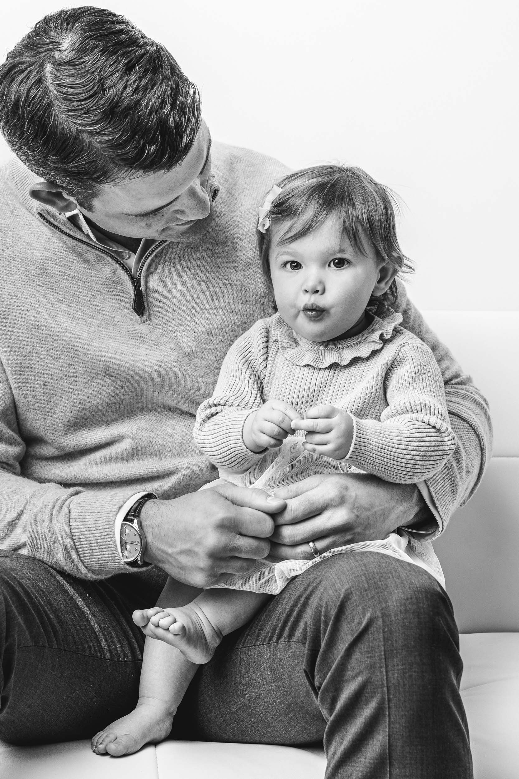  A dad holding his baby girl on his lap captured by Professional Nicole Hawkins Photography. father daughter pic #NicoleHawkinsPhotography #NicoleHawkinsBabies #studiochildren #firstbirthday #studiophotography #girlsbirthdayportraits 