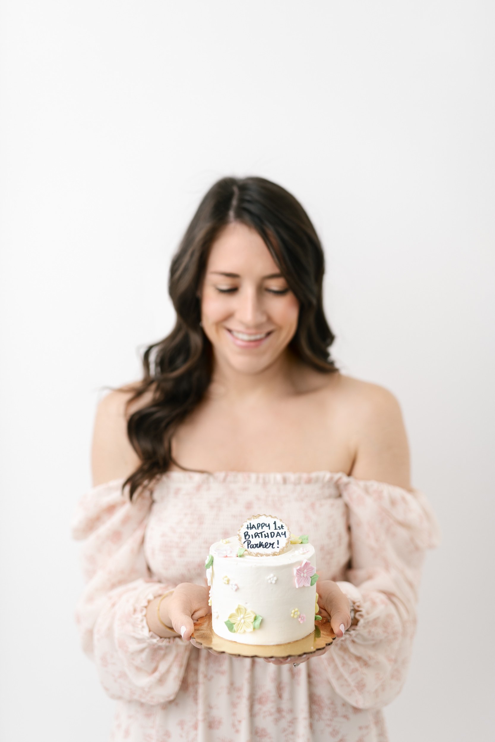  A mother holds her daughter’s first birthday cake captured by Nicole Hawkins Photography in New Jersey. first cake smash cake #NicoleHawkinsPhotography #NicoleHawkinsBabies #studiochildren #firstbirthday #studiophotography #girlsbirthdayportraits 