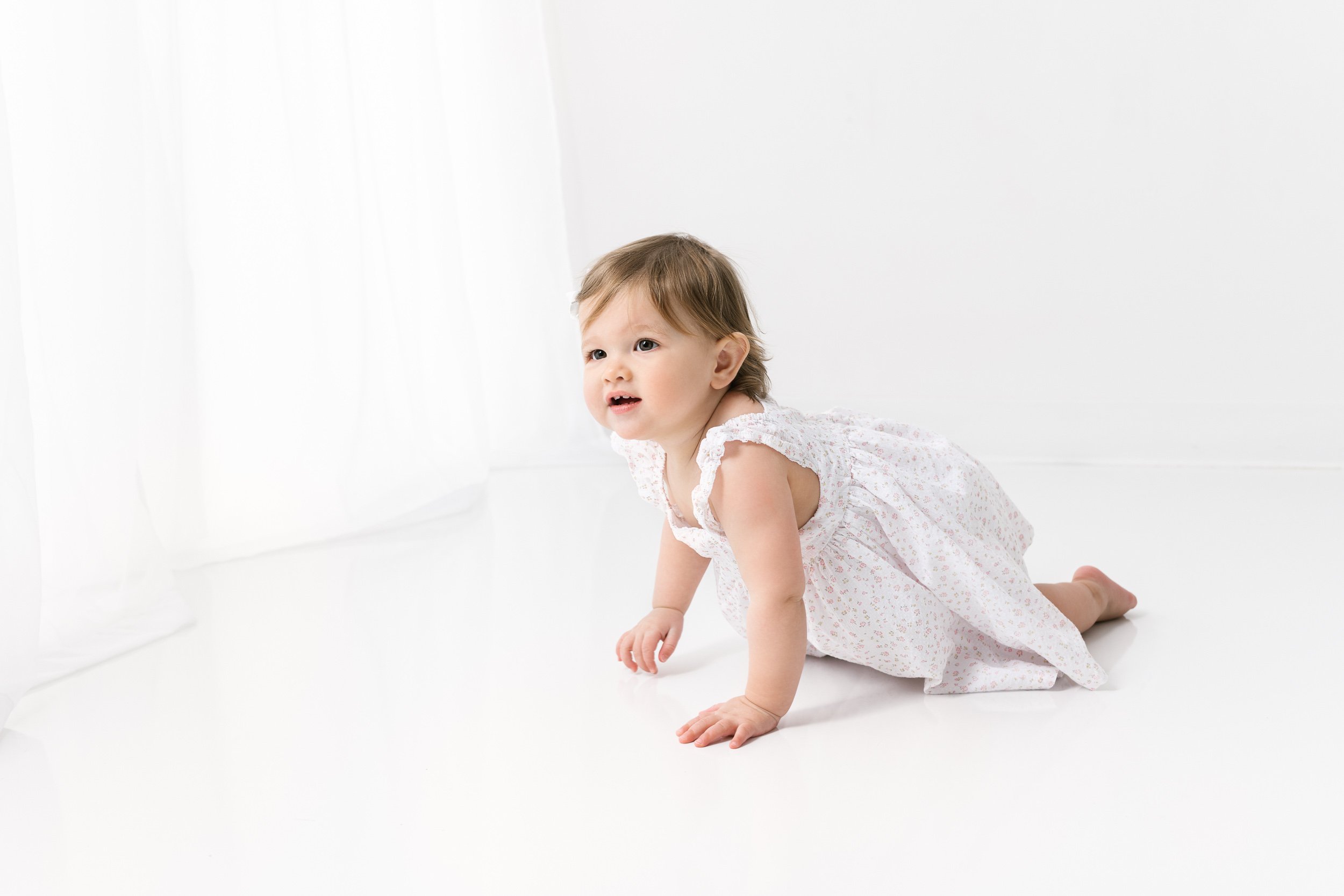  Little girl crawling around a studio for a birthday portrait session by Nicole Hawkins Photography. birthday portraits baby #NicoleHawkinsPhotography #NicoleHawkinsBabies #studiochildren #firstbirthday #studiophotography #girlsbirthdayportraits 