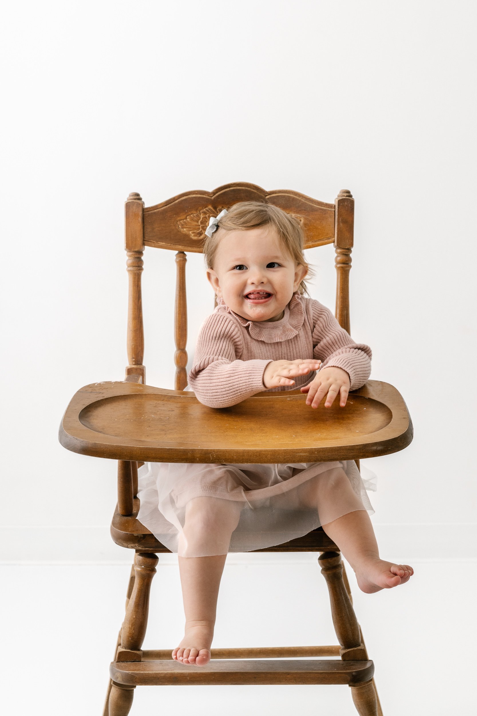 Nicole Hawkins Photography captures a portrait of a baby sitting in a vintage high chair in a studio. vintage high chair #NicoleHawkinsPhotography #NicoleHawkinsBabies #studiochildren #firstbirthday #studiophotography #girlsbirthdayportraits 