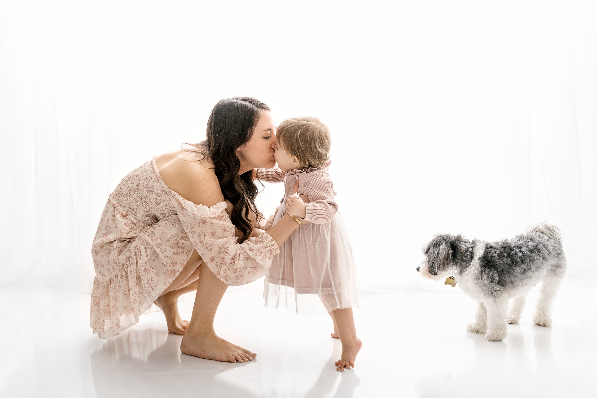  A momma kisses her baby girl during a first birthday session in NJ with Nicole Hawkins Photography. mother and daughter kisses #NicoleHawkinsPhotography #NicoleHawkinsBabies #studiochildren #firstbirthday #studiophotography #girlsbirthdayportraits 