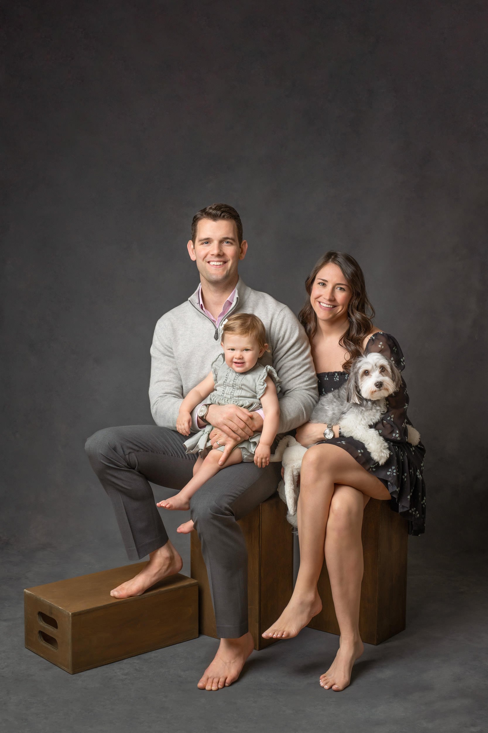  Family portrait with a little girl and dog taken in a studio with dark background by Nicole Hawkins Photography. family dog #NicoleHawkinsPhotography #NicoleHawkinsBabies #studiochildren #firstbirthday #studiophotography #girlsbirthdayportraits 