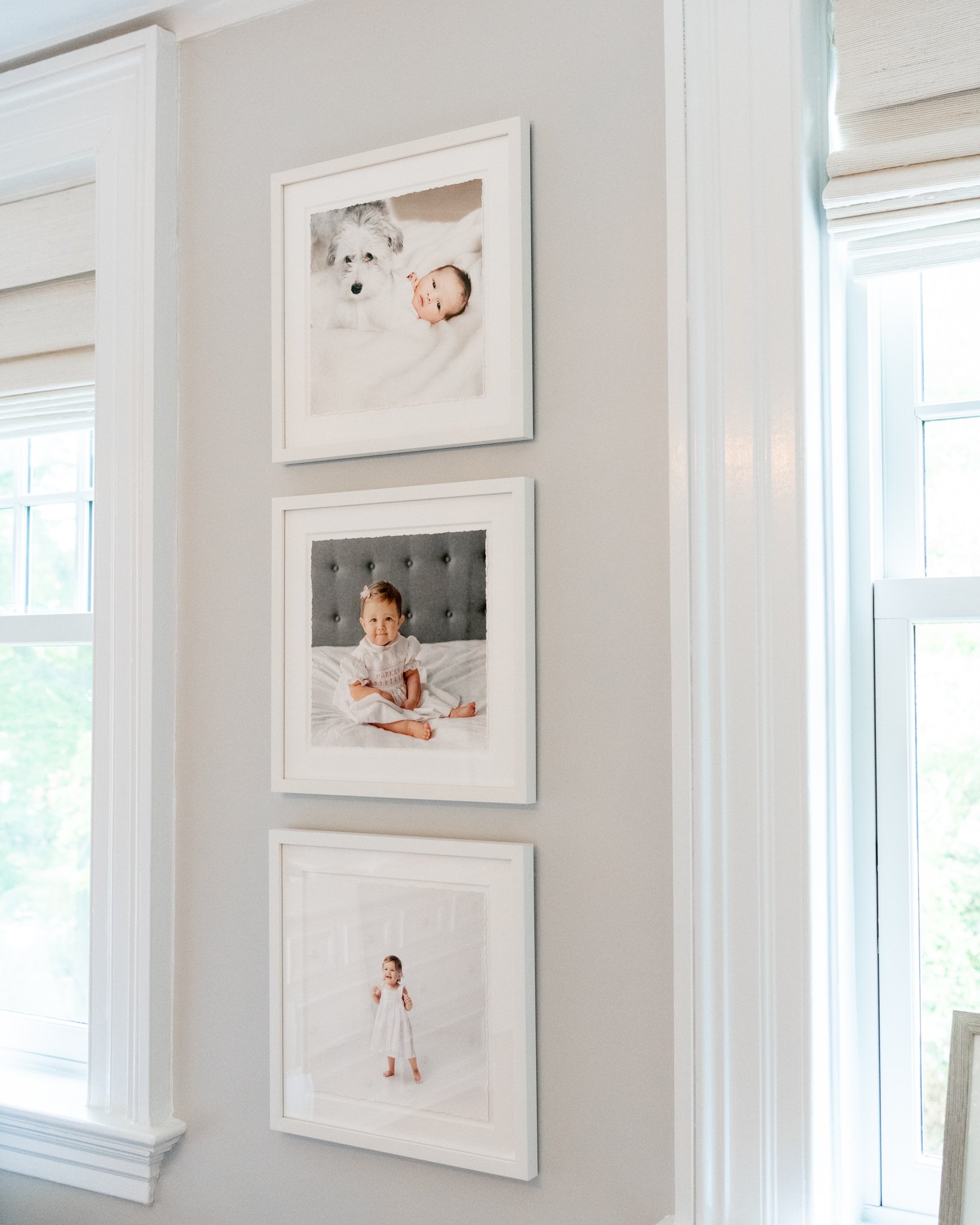  Three newborn portraits taken by Nicole Hawkins Photography are displayed on a living room wall in New Jersey. newborn photo #NicoleHawkinsPhotography #NicoleHawkinsBabies #studiochildren #firstbirthday #studiophotography #girlsbirthdayportraits 