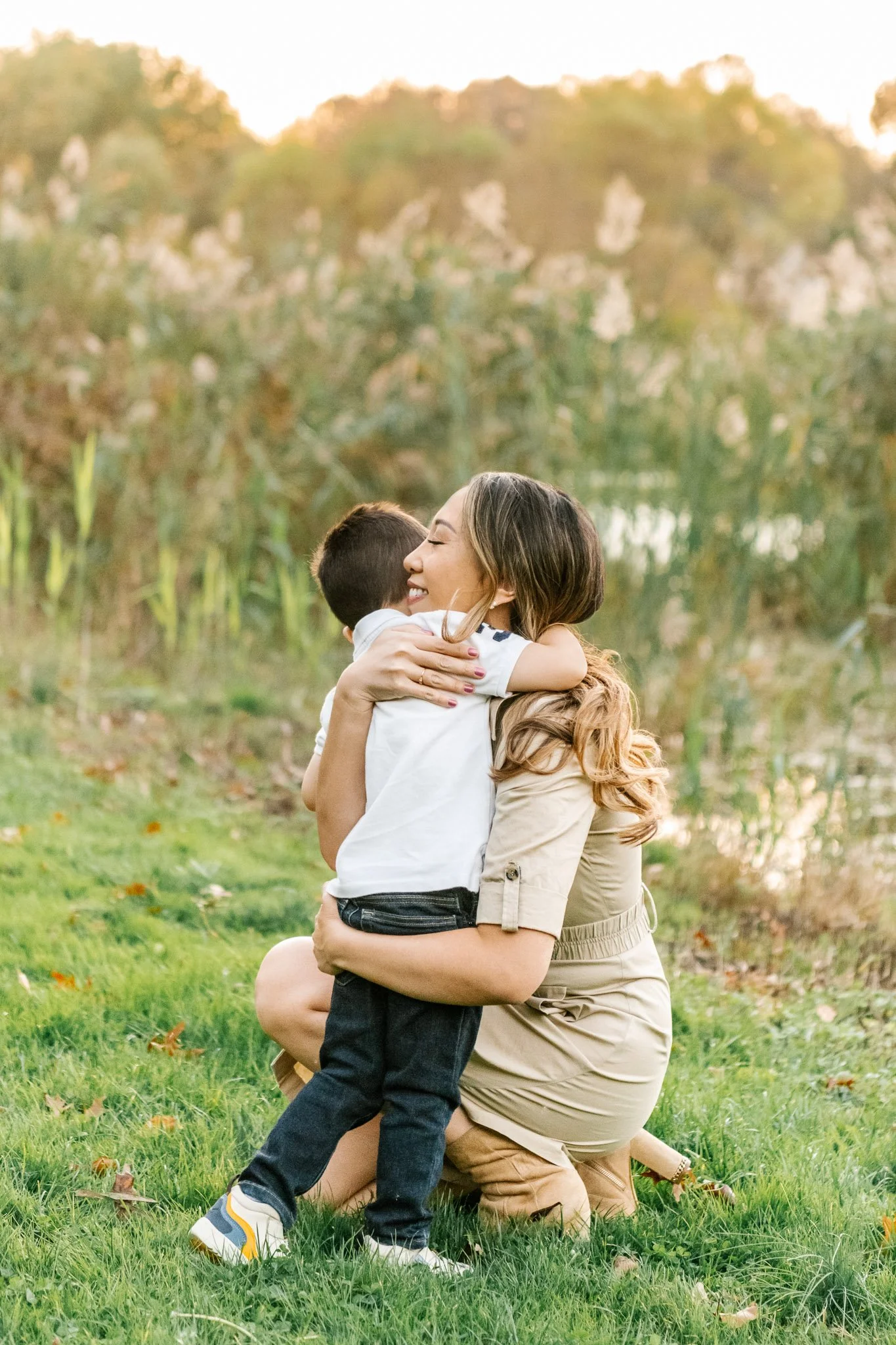  An only child hugs his mother during a family session with Nicole Hawkins Photography. genuine motherhood moment #NicoleHawkinsPhotography #NicoleHawkinsFamilies #fallfamilyphotos #NorthernNewJerseyPhotography #outdoorfamilyportraits 