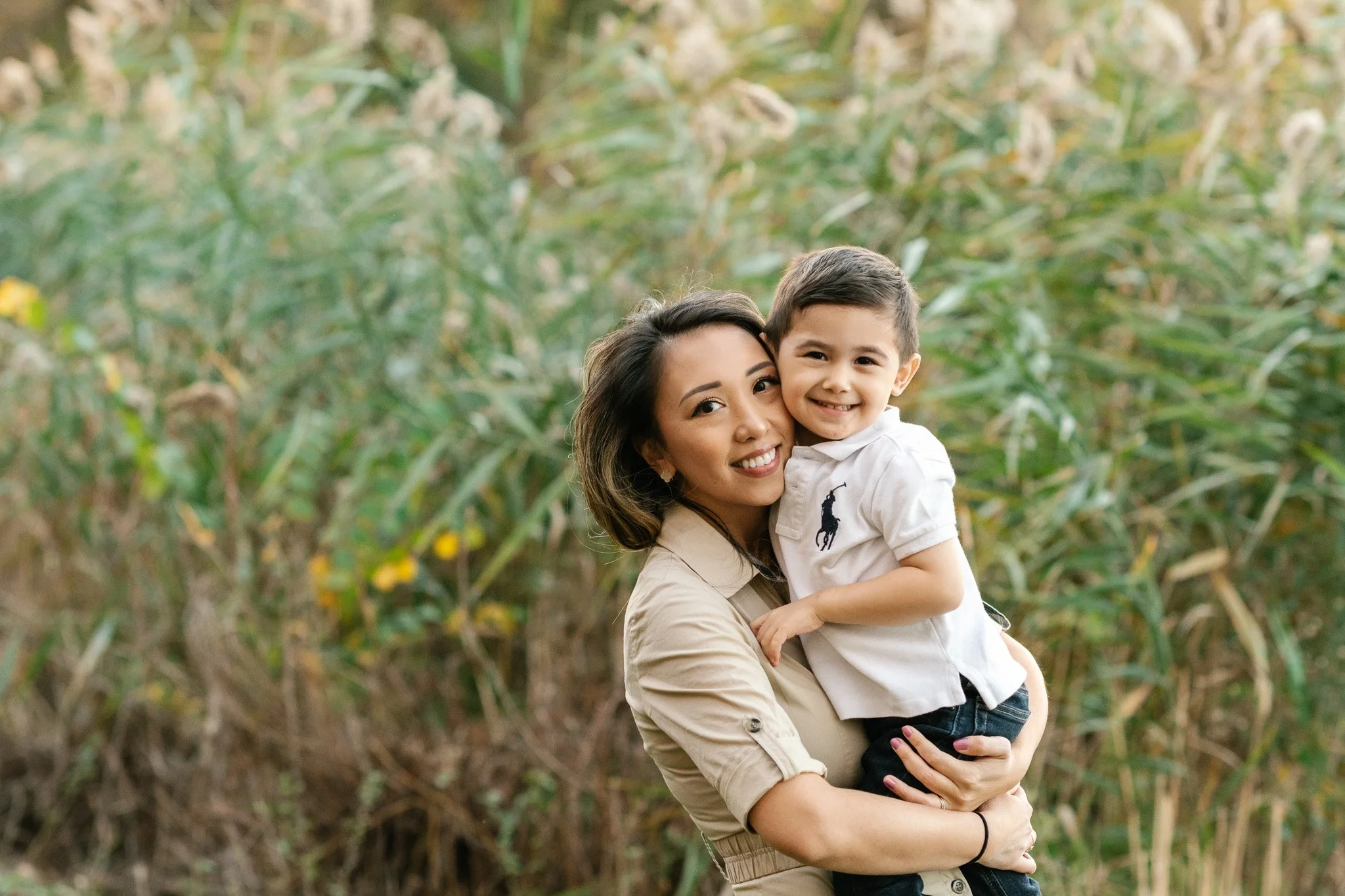  A mother and little boy press their cheeks together and smile by Nicole Hawkins Photography. mother and son portrait #NicoleHawkinsPhotography #NicoleHawkinsFamilies #fallfamilyphotos #NorthernNewJerseyPhotography #outdoorfamilyportraits 