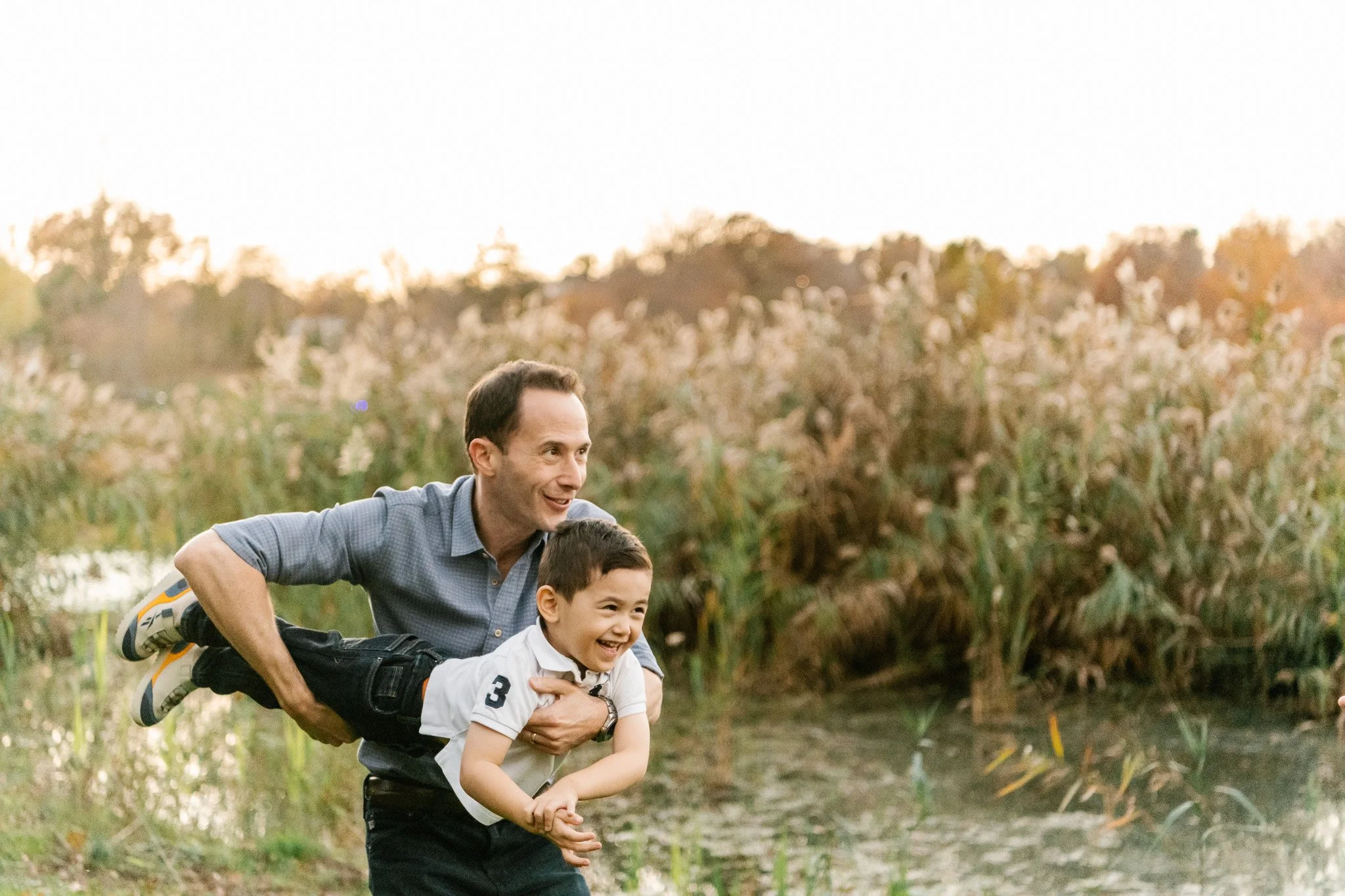  Nicole Hawkins Photography captures a father playing with his toddler boy outdoors in New Jersey. boy playing with dad #NicoleHawkinsPhotography #NicoleHawkinsFamilies #fallfamilyphotos #NorthernNewJerseyPhotography #outdoorfamilyportraits 