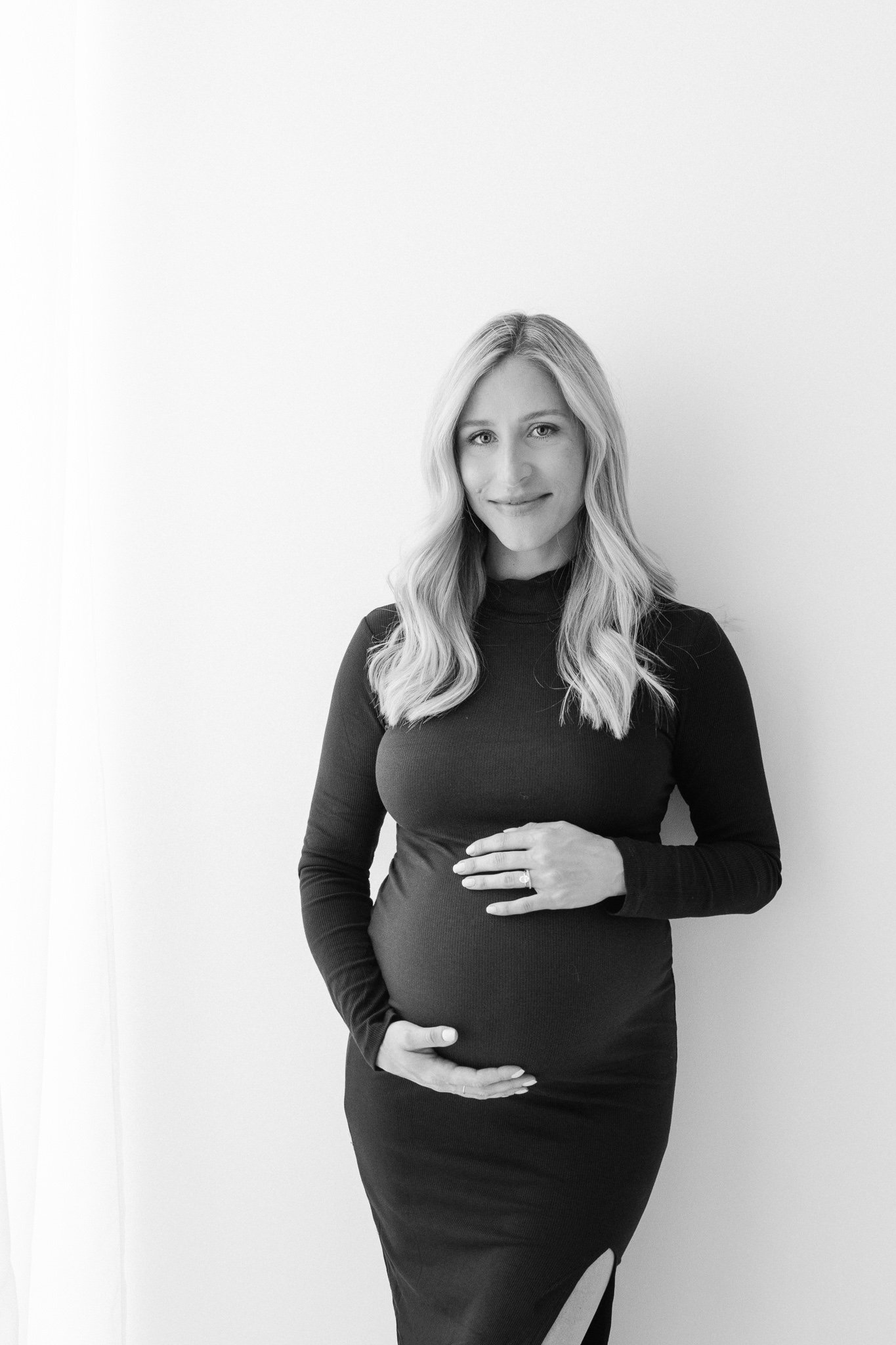  Modern style studio maternity portrait with a mother wearing a black long-sleeve dress by Nicole Hawkins Photography. stunning maternity #NicoleHawkinsPhotography #NicoleHawkinsMaternity #Studiomaternityportraits #NewJerseymaternity #NewYorkMaternit