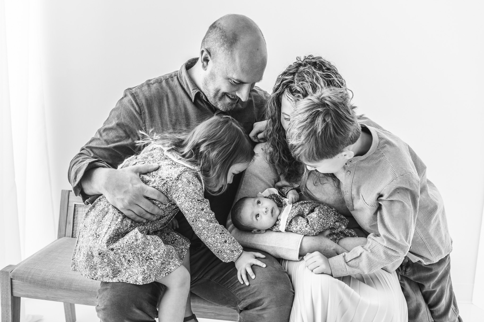  Family of five adoring their newborn baby sister at a studio in New Jersey by Nicole Hawkins Photography. newborn focus family pic #NicoleHawkinsPhotography #NicoleHawkinsFamily #Newborns #MaplewoodNJ #studiofamilyportraits #modernfamilyportraits 