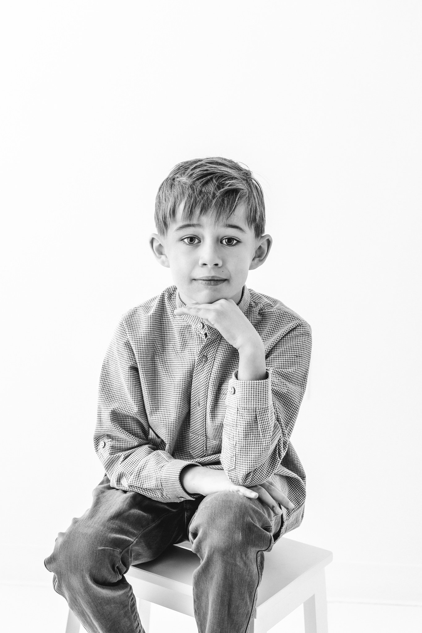  The oldest child rests his chin on his hand in a black and white portrait by Nicole Hawkins Photography. children poses #NicoleHawkinsPhotography #NicoleHawkinsFamily #Newborns #MaplewoodNJ #studiofamilyportraits #modernfamilyportraits 