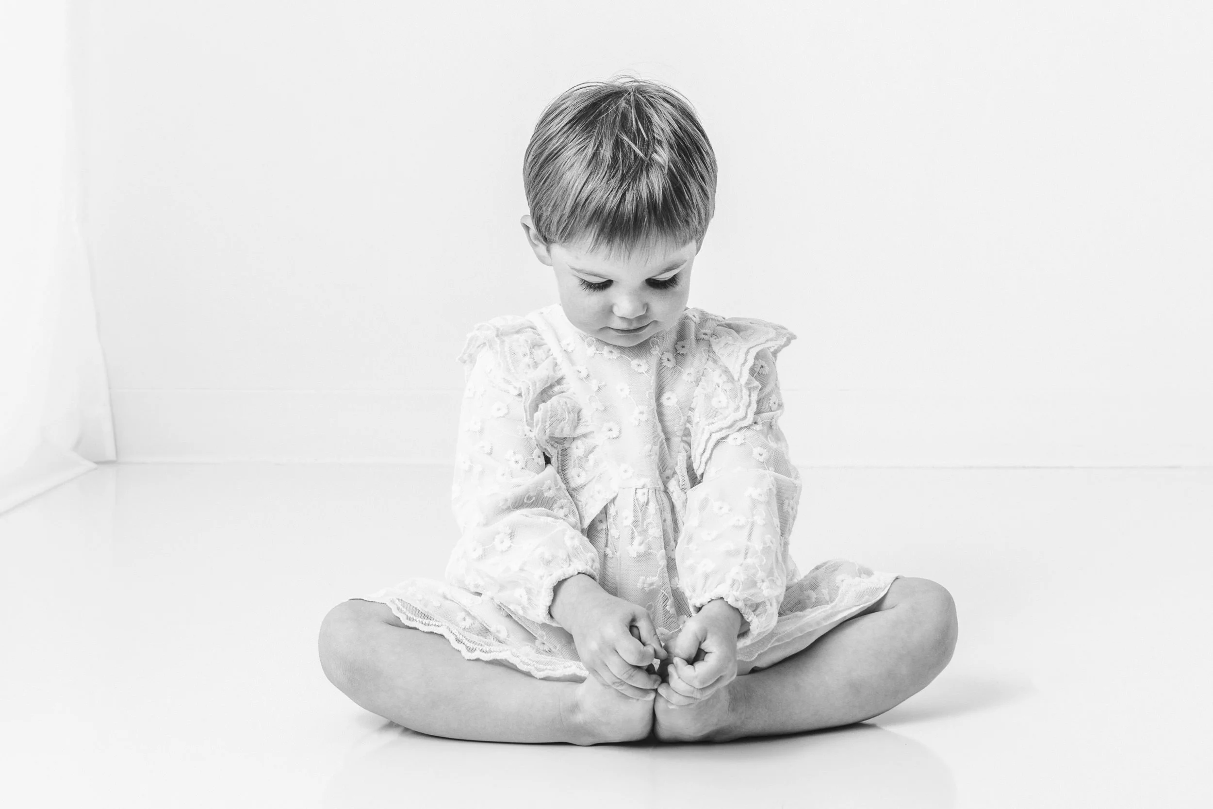  Black and white studio portrait of a little girl for a milestone birthday session with Nicole Hawkins Photography. kid poses with toes #NicoleHawkinsPhotography #NicoleHawkinsChildren #3rdbirthday #studioportrait #agirlandherbunny #littlegirl  