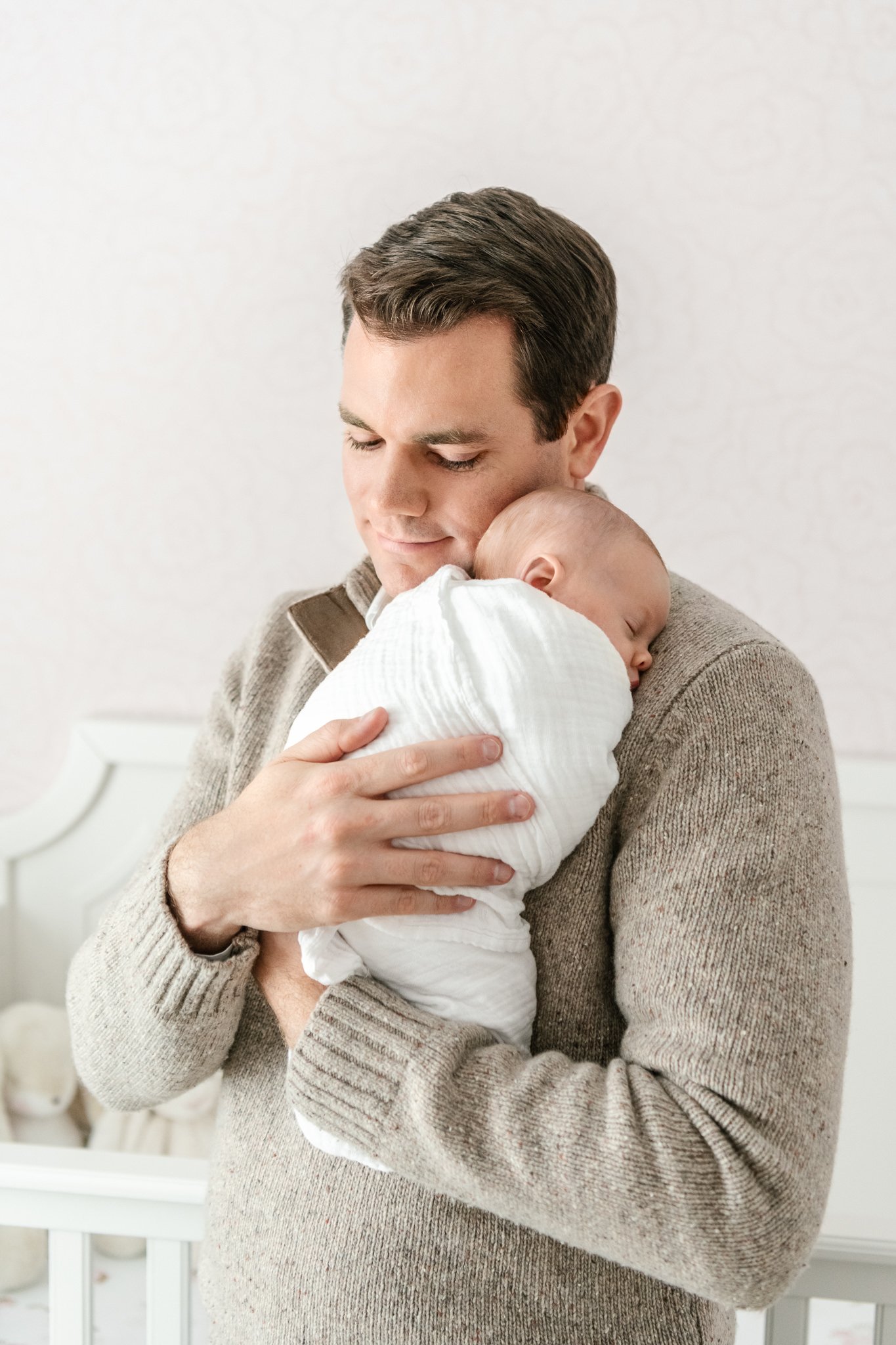  Nicole Hawkins Photography captures a father snuggling his newborn baby in a nursery. father and baby portraits snuggles #NicoleHawkinsPhotography #NicoleHawkinsNewborns #InHomeNewborns #NewJerseyNewborns #NewYorkNewborns #babygirlnewborns 