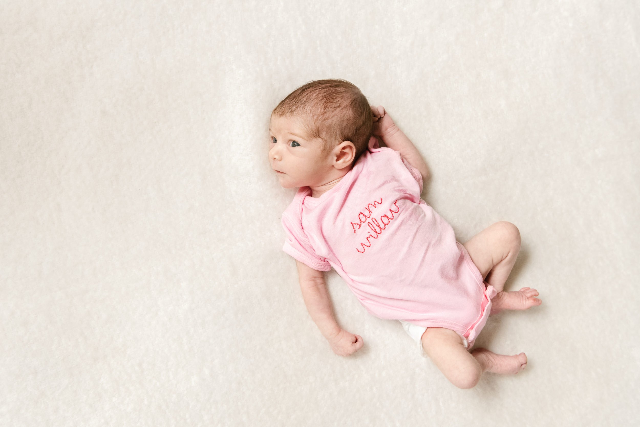  Nicole Hawkins Photography captures a newborn with an embroidered onesie with her name on it. NJ newborn photography #NicoleHawkinsPhotography #NicoleHawkinsFamily #Newborns #InHomeNewborns #NicoleHawkinsNewborns #NJnewborns #babygirl 