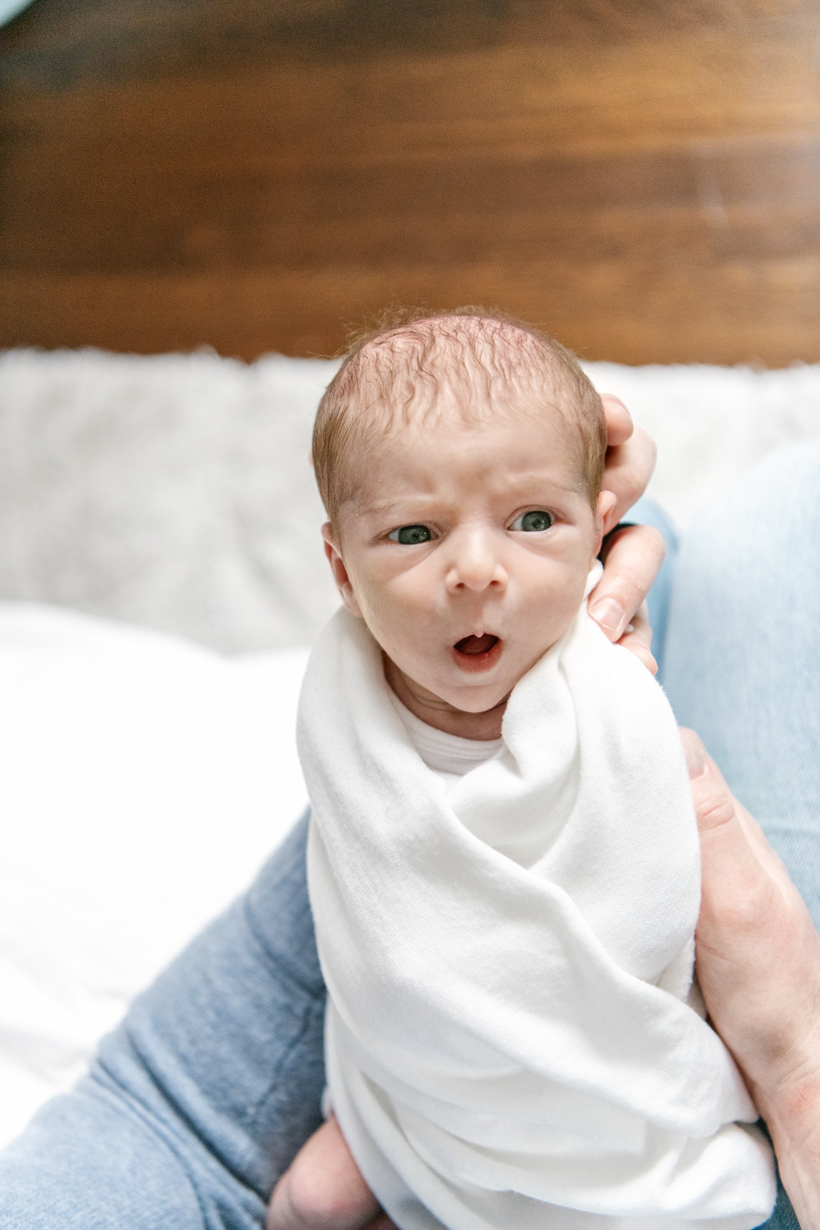  Baby being held by dad with eyes open and yawning captured by Nicole Hawkins Photography in NJ. New Jersey Photographers family #NicoleHawkinsPhotography #NicoleHawkinsFamily #Newborns #InHomeNewborns #NicoleHawkinsNewborns #NJnewborns #babygirl 