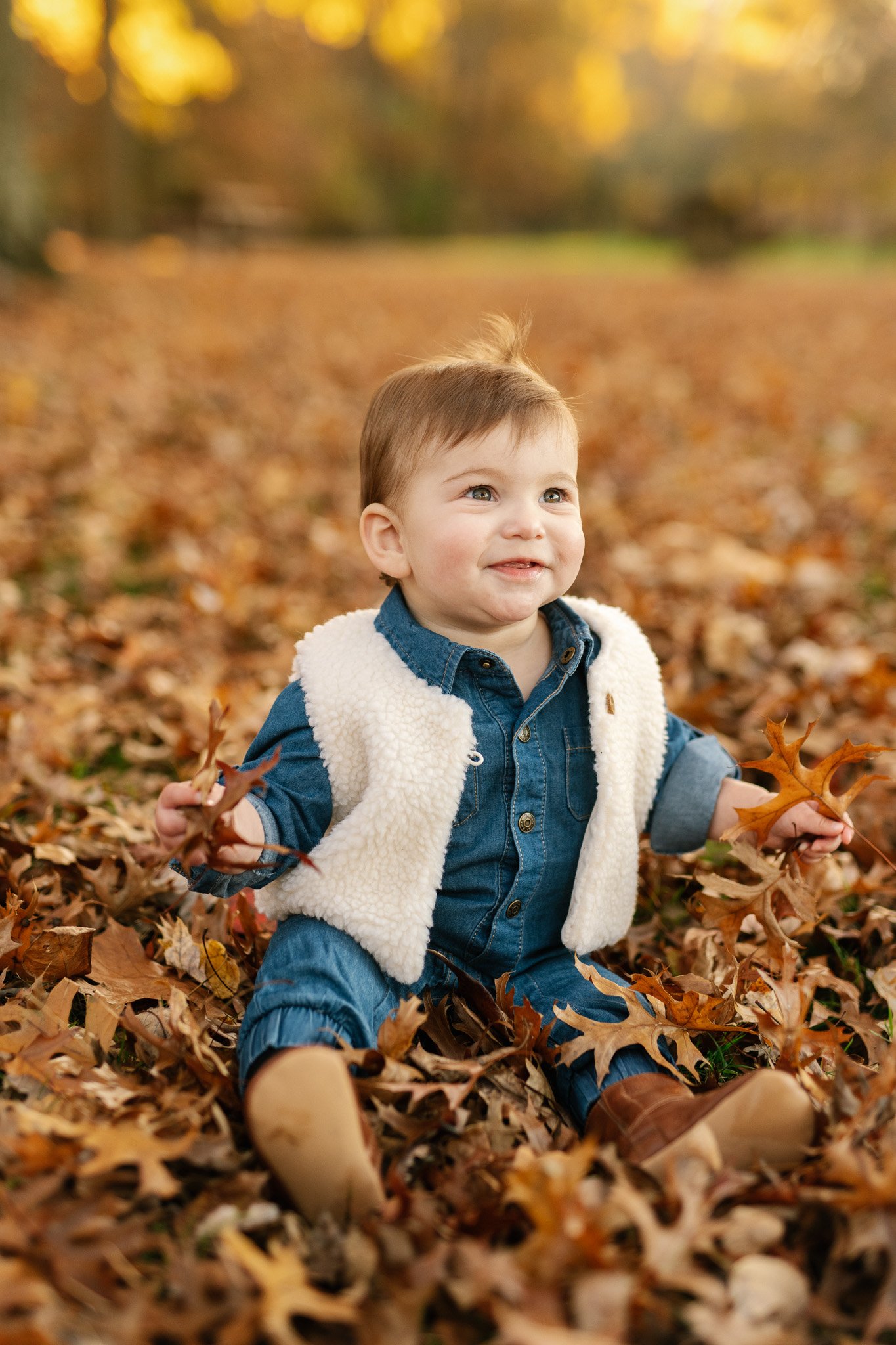  A baby sitting in a pile of leaves in the fall in New Jersey by Nicole Hawkins Photography. fall family pic ideas baby style ideas #NicoleHawkinsPhotography #NicoleHawkinsFamily #fallfamilyphotos #fallphotos #familyphotographerNJ #NJfallfamilypics 