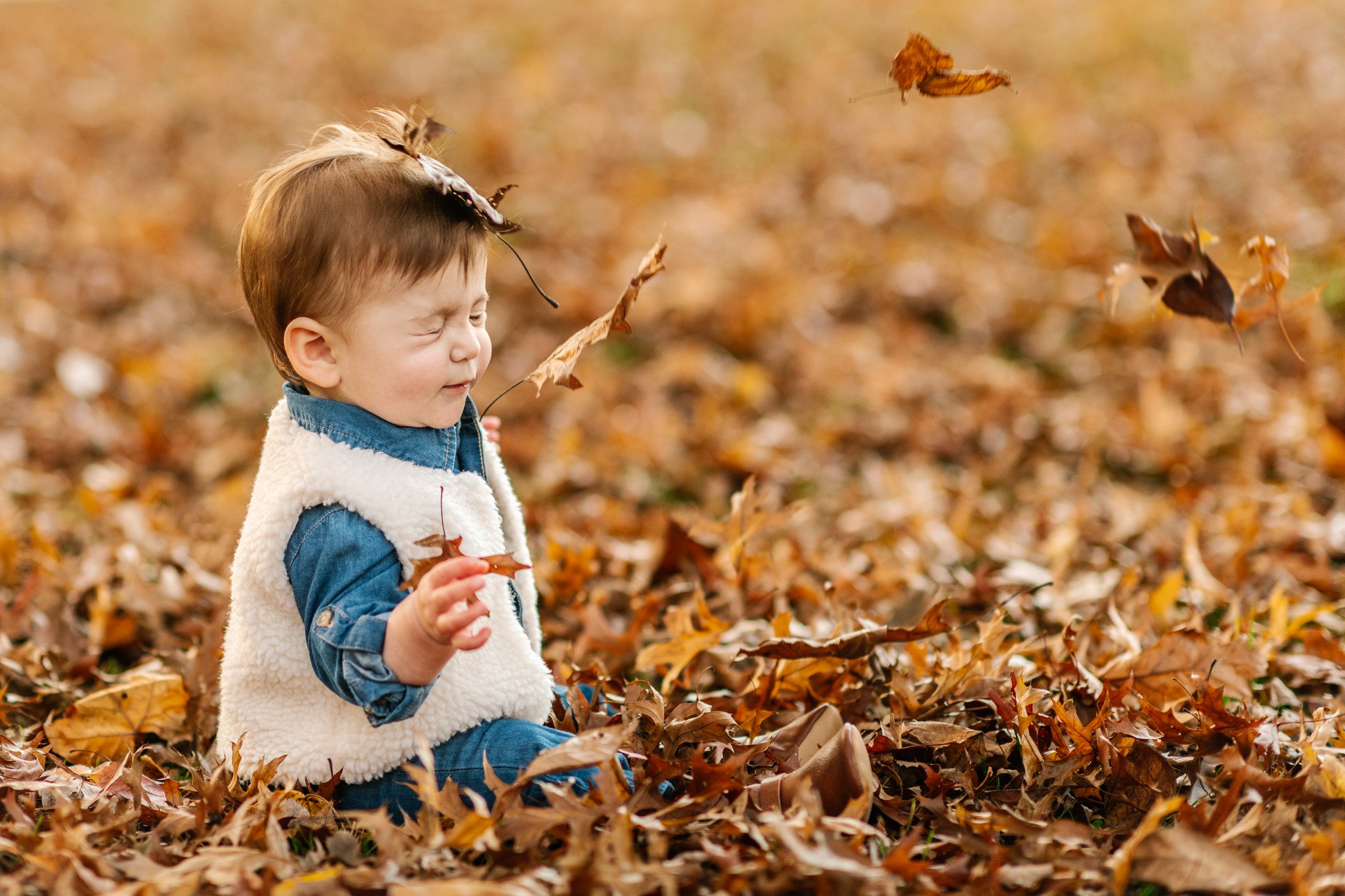  Fall family portrait of a baby girl throwing leaves by Nicole Hawkins Photography in New Jersey. fall portraits with leaves #NicoleHawkinsPhotography #NicoleHawkinsFamily #fallfamilyphotos #fallphotos #familyphotographerNJ #NJfallfamilypics 