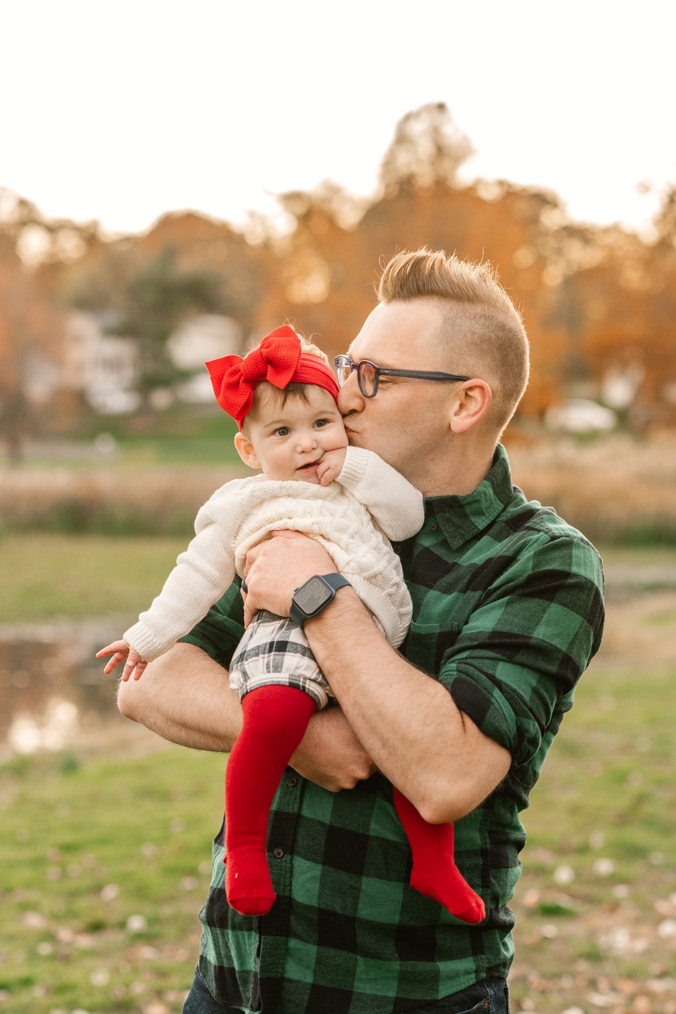  A father kisses his little girl's cheek during fall family pictures in New Jersey with Nicole Hawkins Photography. baby girl #NicoleHawkinsPhotography #NicoleHawkinsFamily #fallfamilyphotos #fallphotos #familyphotographerNJ #NJfallfamilypics 