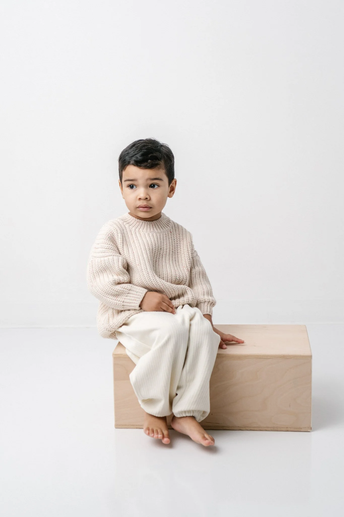  A toddler boy in neutral colors sits on a wooden box captured by Nicole Hawkins Photography. neutral photos #NicoleHawkinsPhotograaphy #NicoleHawkinsChildren #StudioBabies&amp;Children #NJphotographers #modernportraits #mom&amp;meportraits  