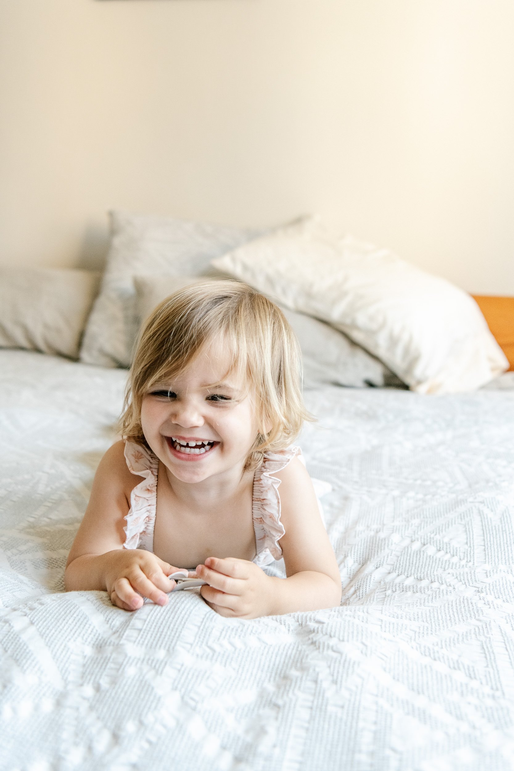  A little girl lays on her bed and laughs captured by Nicole Hawkins Photography. children portraits professional #NicoleHawkinsPhotograaphy #NicoleHawkinsChildren #NewYorkPortraits #KidsinNewYork #ChildrensPortraits #lifestyleportraits 