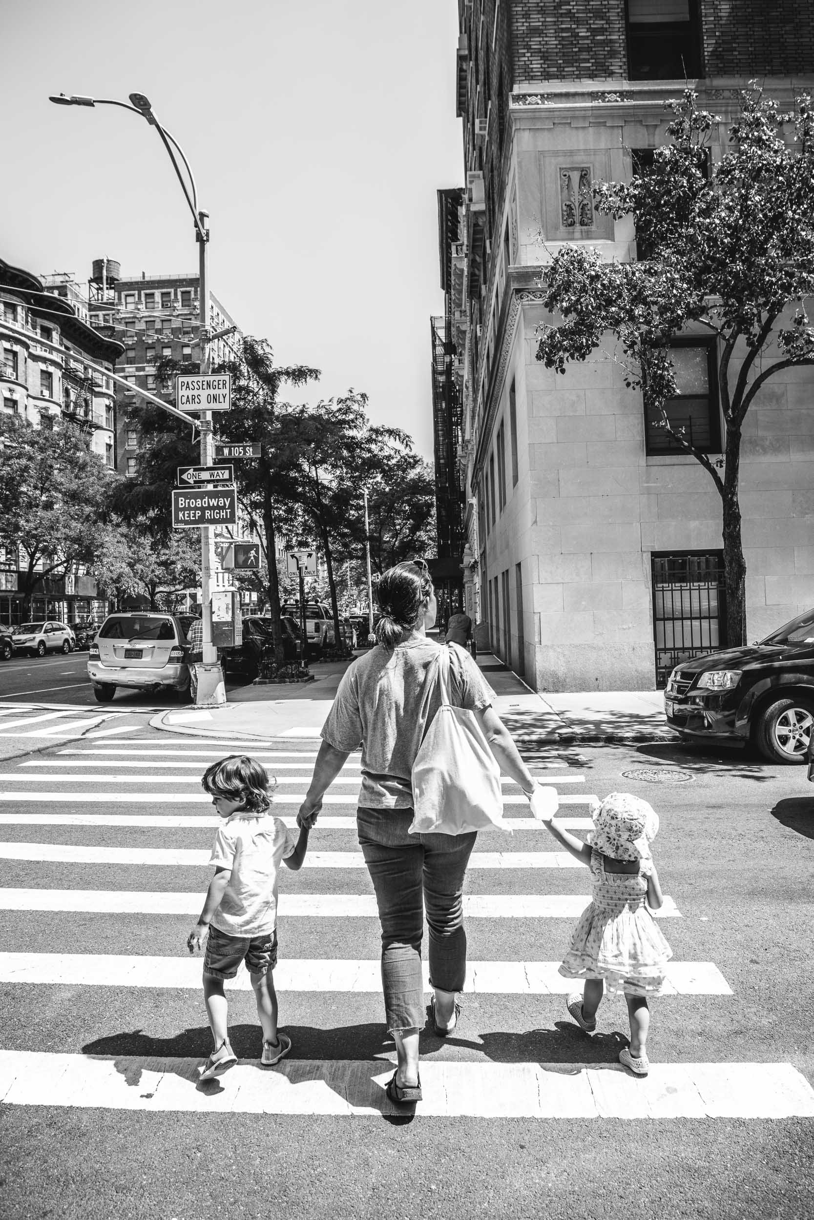  A mother holds her children's hands while crossing a street in NYC by Nicole Hawkins Photography. NYC lifestyle #NicoleHawkinsPhotograaphy #NicoleHawkinsChildren #NewYorkPortraits #KidsinNewYork #ChildrensPortraits #lifestyleportraits 