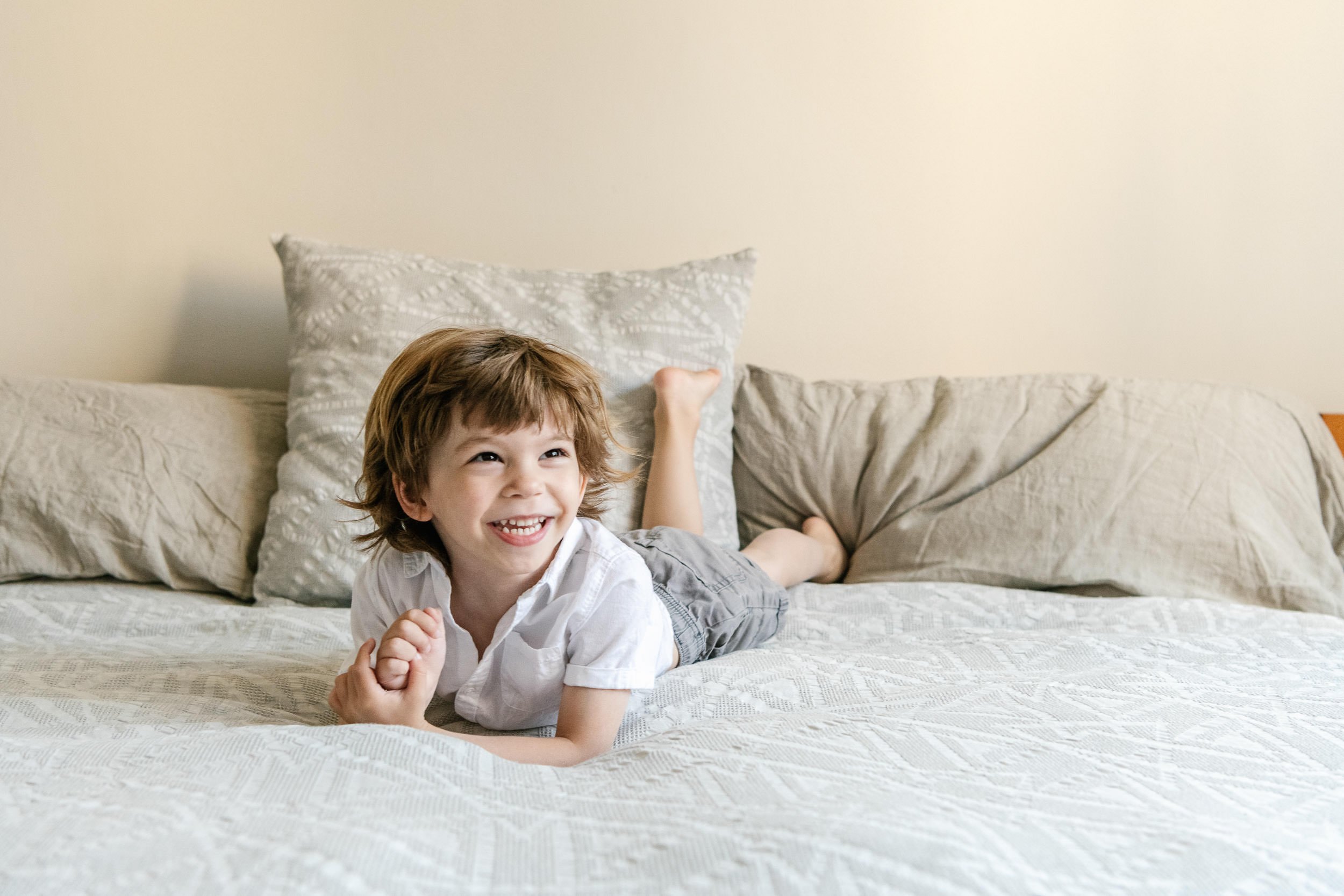  In the New York City area, Nicole Hawkins Photography captures a portrait of a young boy laughing on the bed. family photo #NicoleHawkinsPhotograaphy #NicoleHawkinsChildren #NewYorkPortraits #KidsinNewYork #ChildrensPortraits #lifestyleportraits 