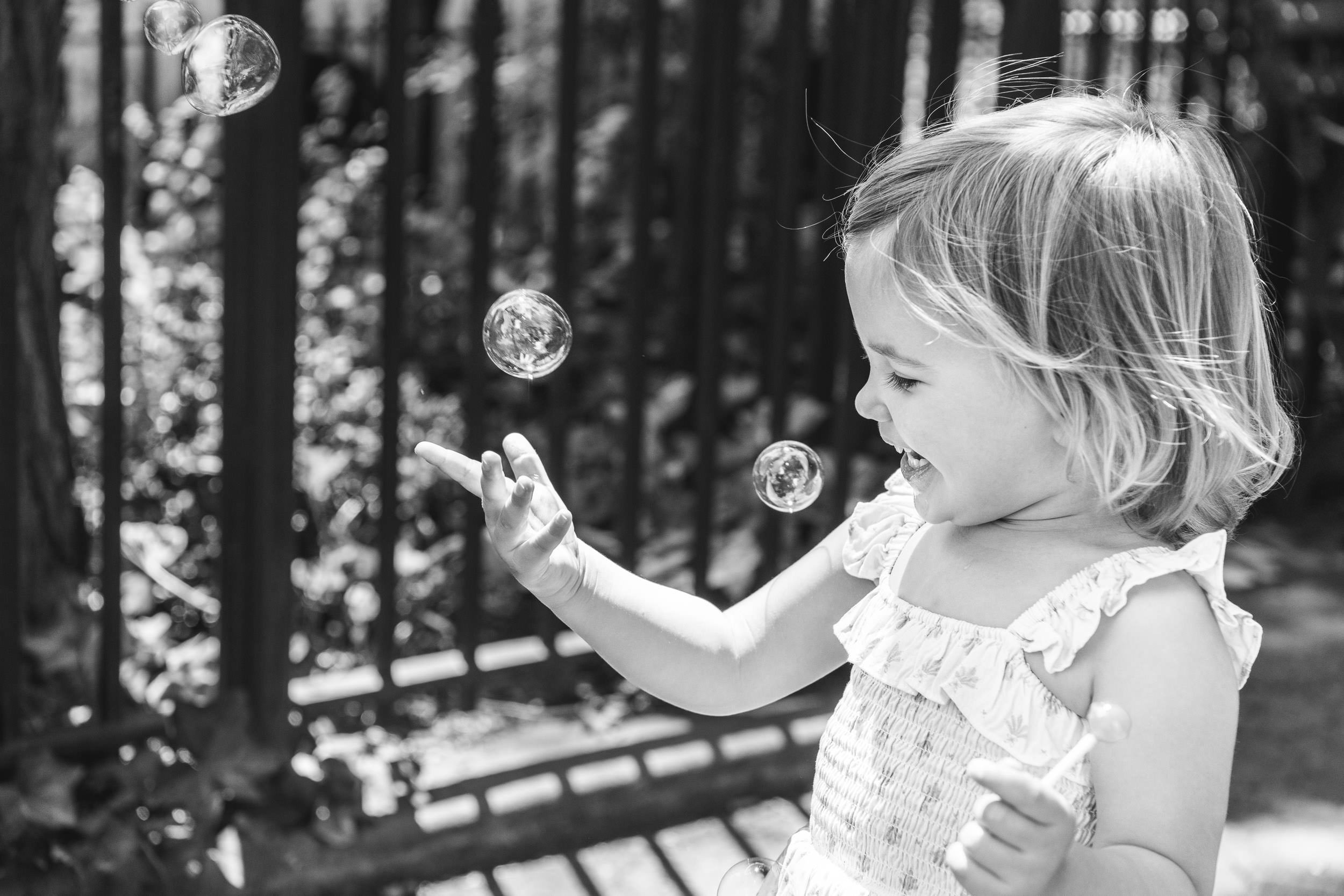  Black and white portrait of a little girl playing with bubbles by Nicole Hawkins Photography. lifestyle portraits #NicoleHawkinsPhotograaphy #NicoleHawkinsChildren #NewYorkPortraits #KidsinNewYork #ChildrensPortraits #lifestyleportraits 
