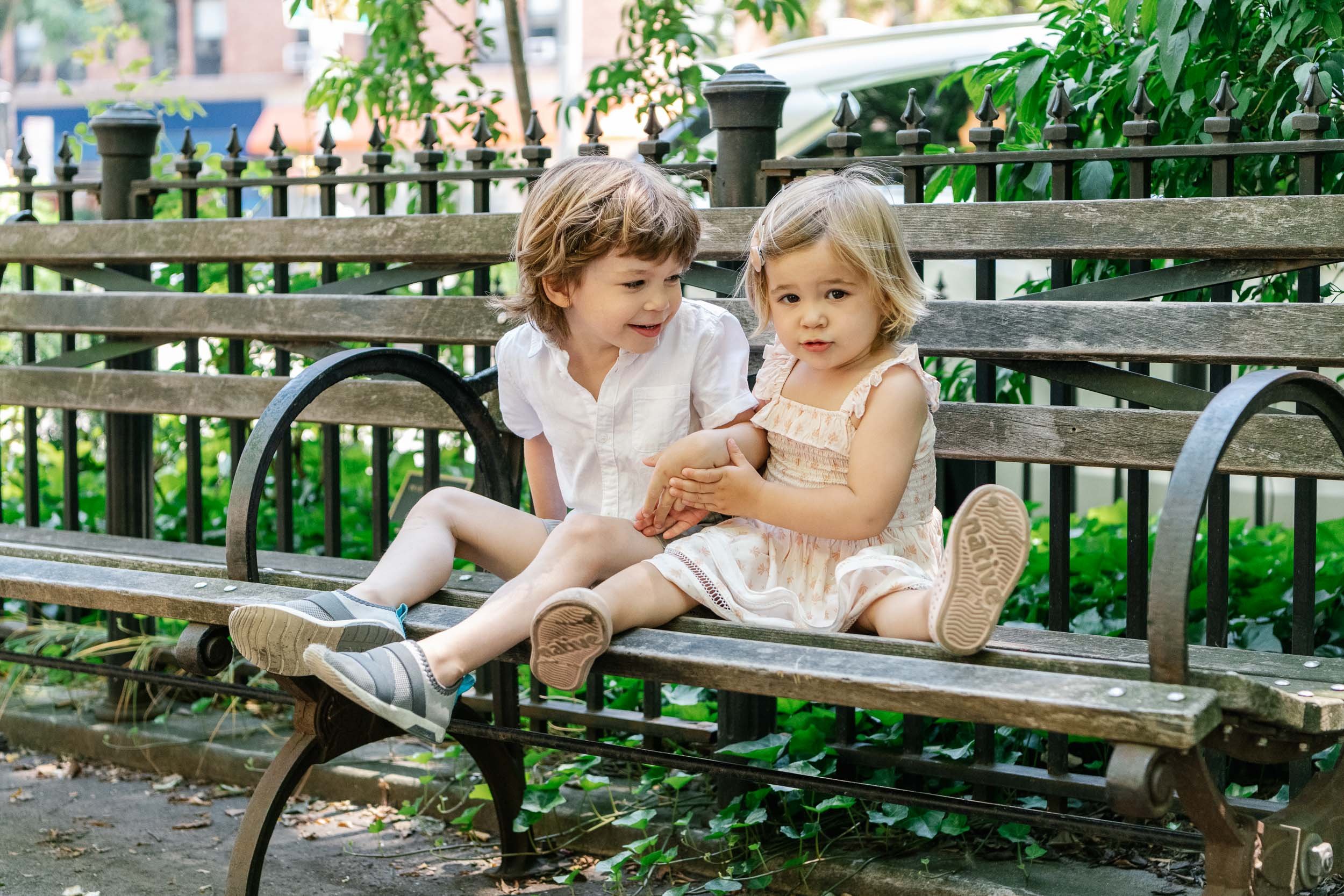  New York City child photography with a boy and girl sitting on a park bench by Nicole Hawkins Photography. park bench #NicoleHawkinsPhotograaphy #NicoleHawkinsChildren #NewYorkPortraits #KidsinNewYork #ChildrensPortraits #lifestyleportraits 