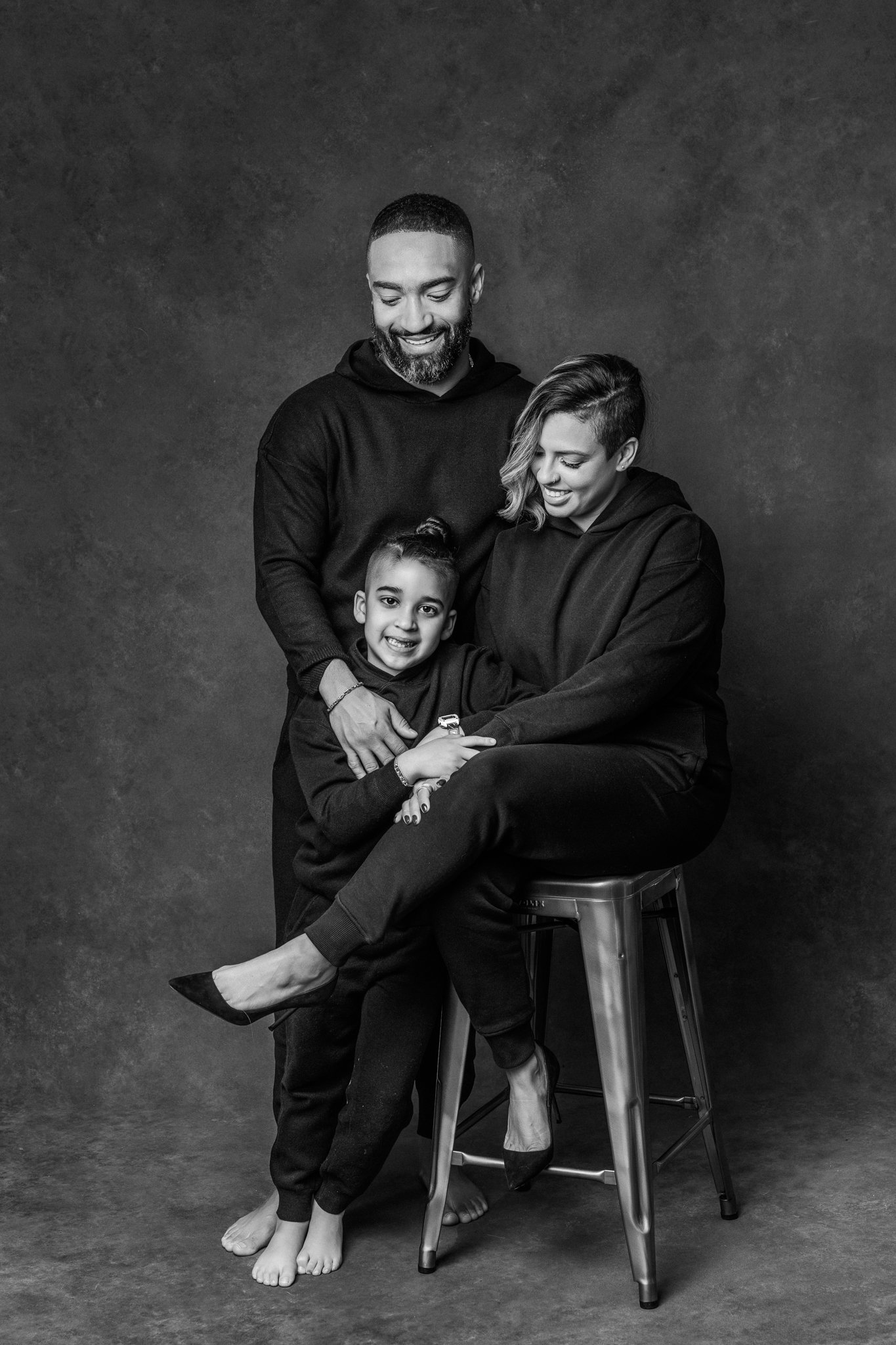  Family of three portraits with a mother and father and child by Nicole Hawkins Photography. black #NicoleHawkinsPhotograaphy #NicoleHawkinsFamilies #Modernfamilypictures #studioportraits #matchingfamilyoutfits #NJphotographer 