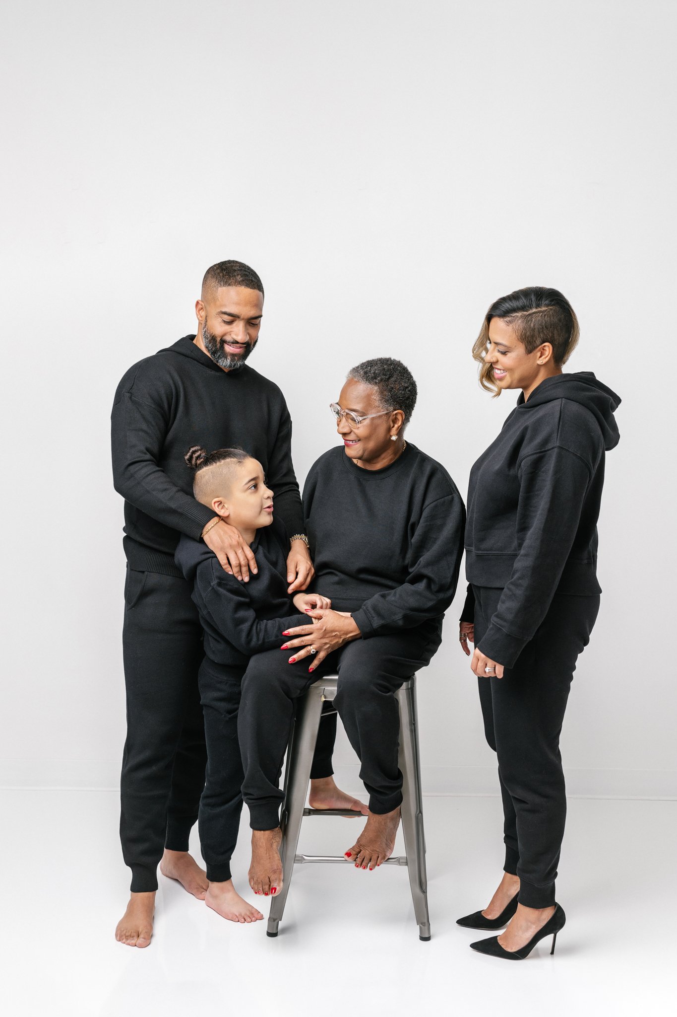  Northern New Jersey photographer Nicole Hawkins Photography captures a family of four smiling at one another. NJ #NicoleHawkinsPhotograaphy #NicoleHawkinsFamilies #Modernfamilypictures #studioportraits #matchingfamilyoutfits #NJphotographer 
