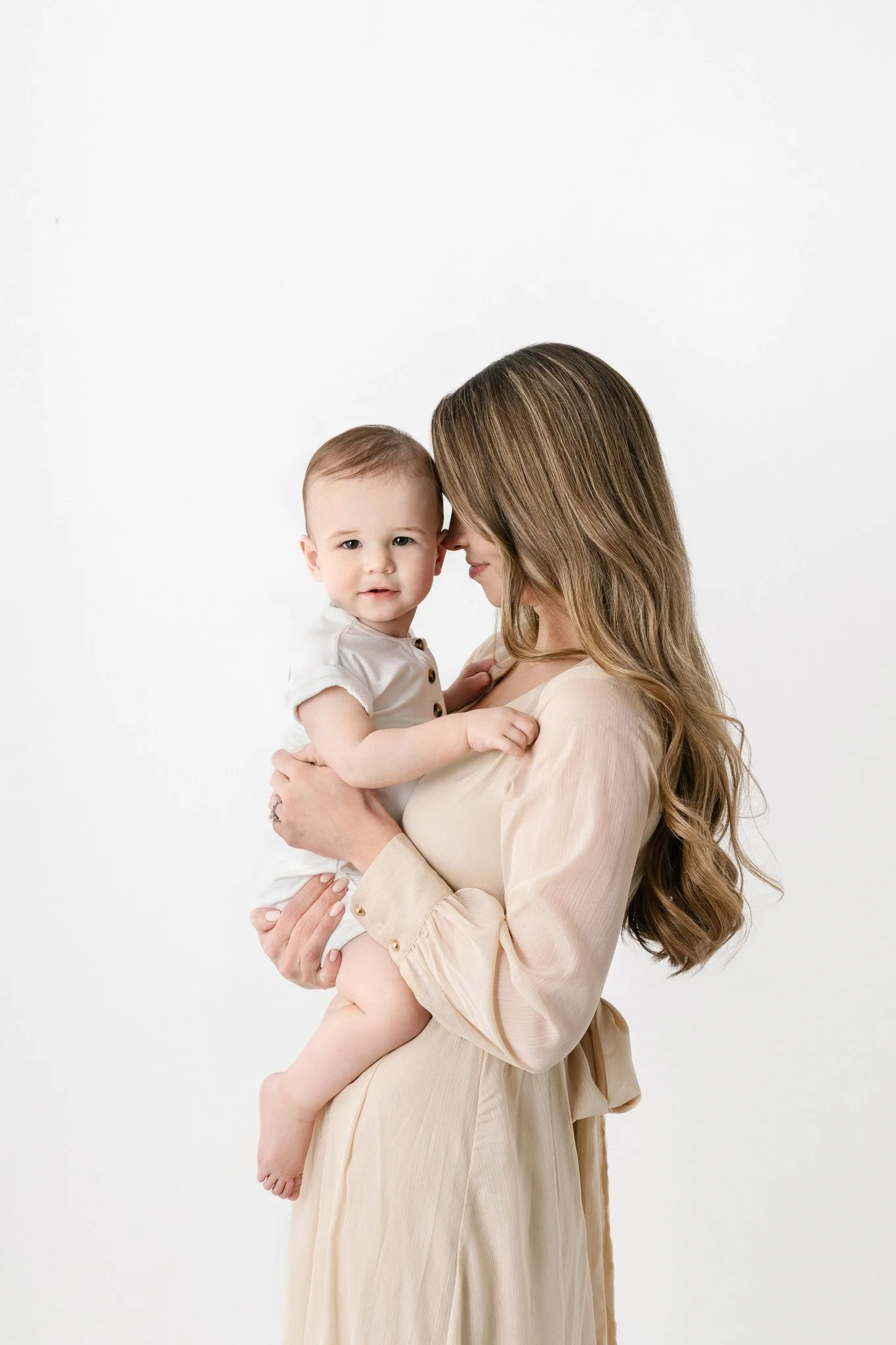  Nicole Hawkins Photography captures a mother resting her head on her baby boys at a white studio in New Jersey. baby birthday portraits outfit ideas #NicoleHawkinsPhotography #NicoleHawkinsBabies #FirstBirthdayPhotography #StudioFamilyPortraits #NJB