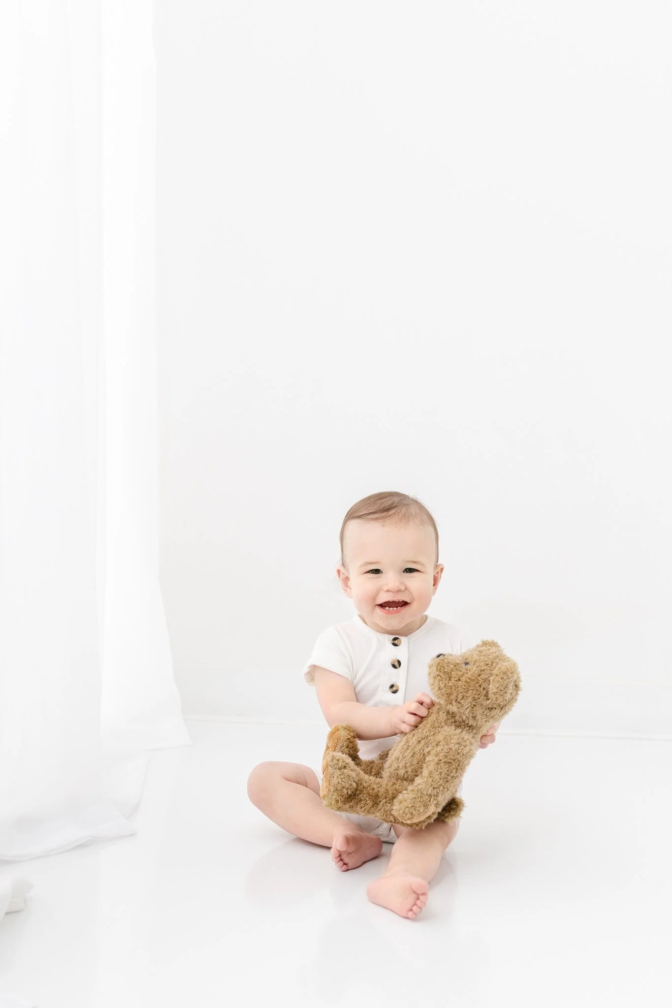  Birthday portraits of a little boy holding a teddy bear sitting on the floor by Nicole Hawkins Photography. teddy bear prop birthday boy #NicoleHawkinsPhotography #NicoleHawkinsBabies #FirstBirthdayPhotography #StudioFamilyPortraits #NJBabies #First