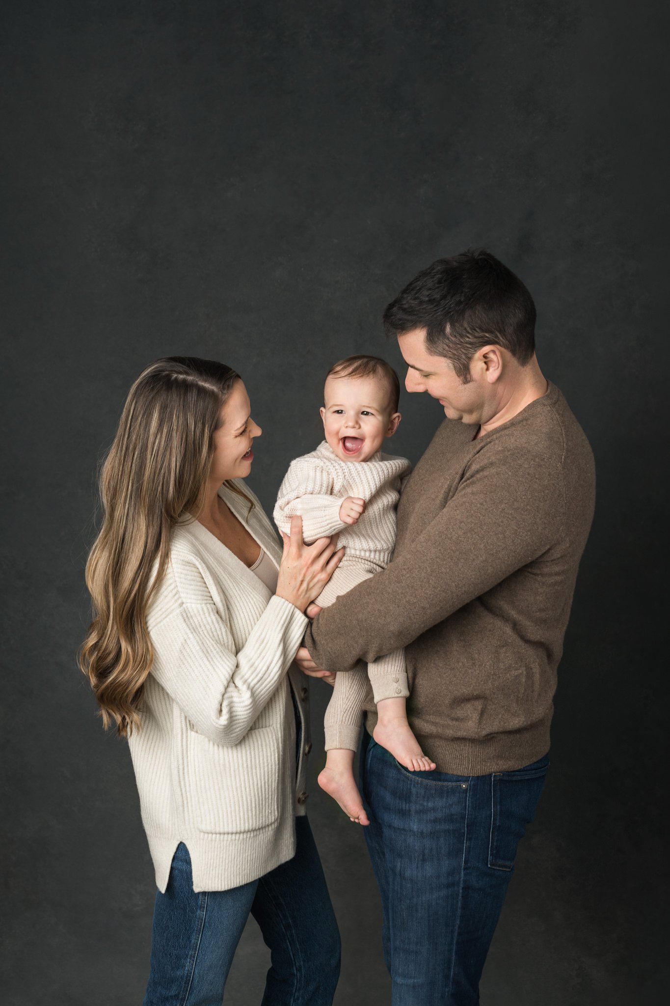  Nicole Hawkins Photography captures a candid portrait of a family during a first birthday portrait session. candid family portraits studio family pictures #NicoleHawkinsPhotography #NicoleHawkinsBabies #FirstBirthdayPhotography #StudioFamilyPortrait