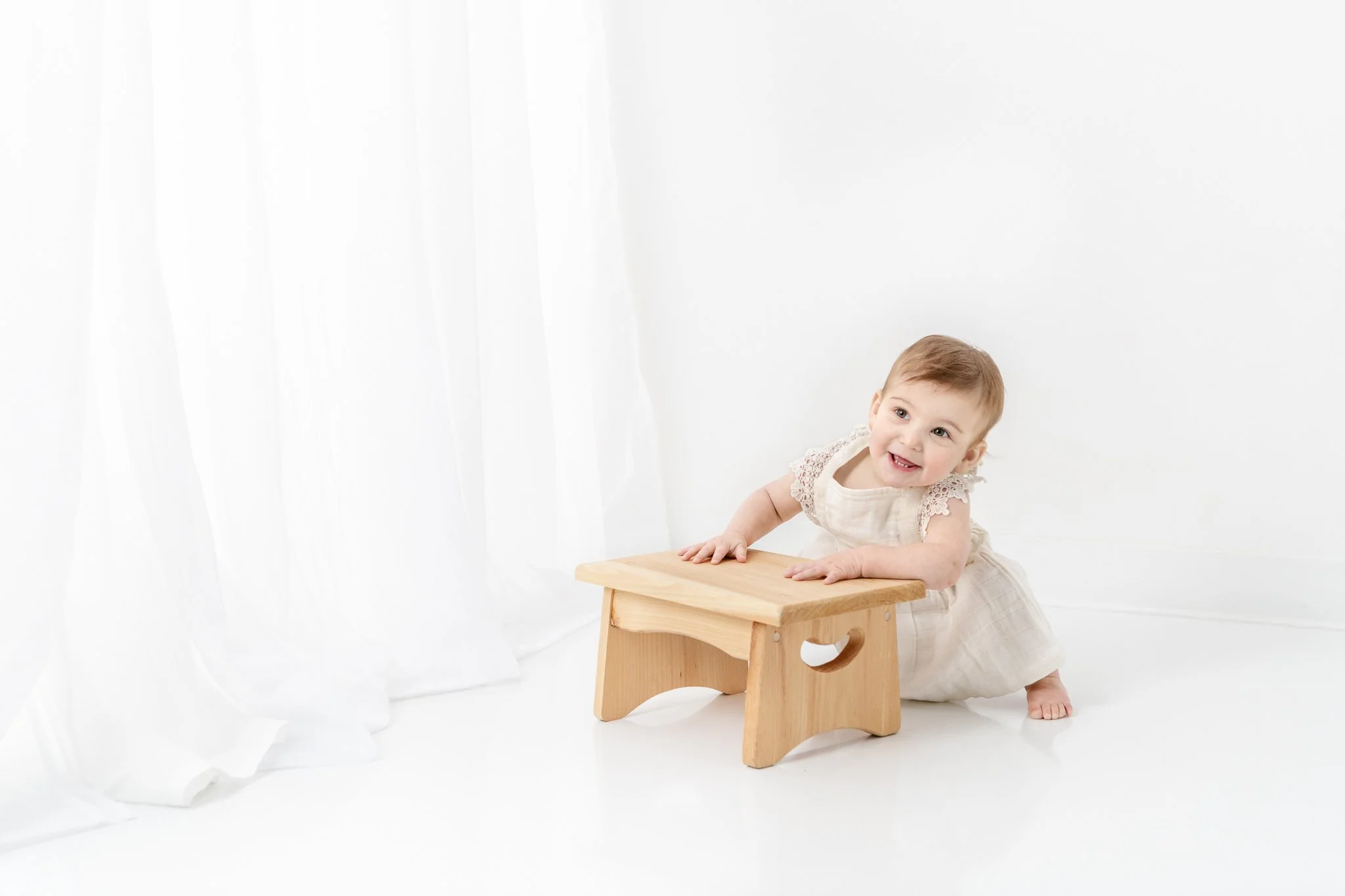  One-year-old girl wears an antique style dress during her first birthday portraits by Nicole Hawkins PHooography. antique baby girl dress throwback baby gown #NicoleHawkinsPhotography #NicoleHawkinsBabies&amp;Children #FirstBirthdayPhotography #Stud