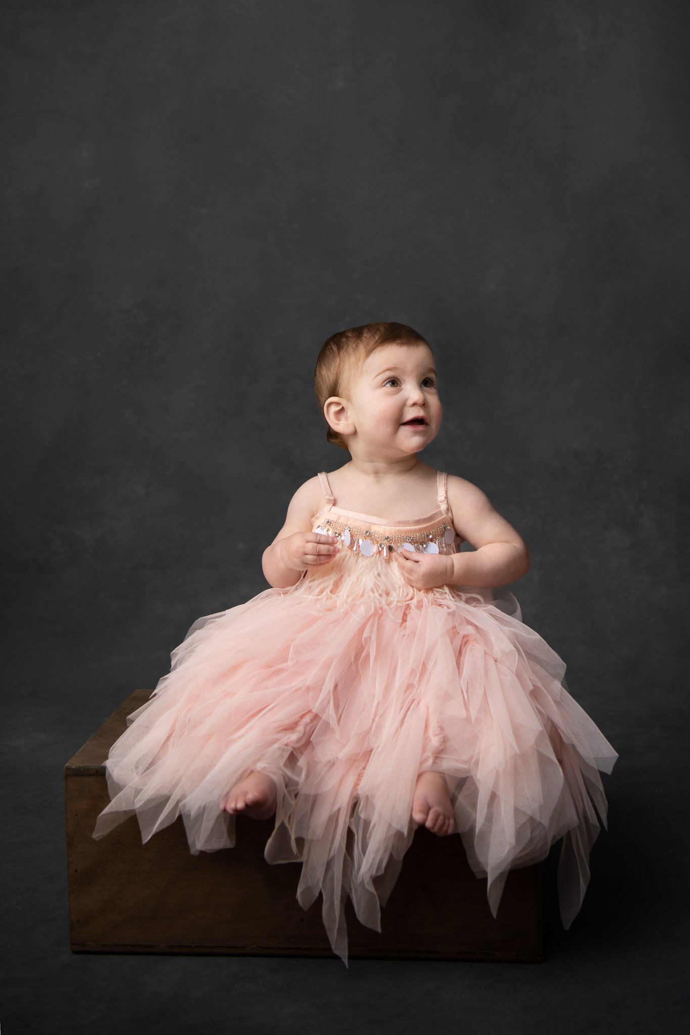  A little girl in a princess dress looks up at her parents captured by Nicole Hawkins Photography. fun little girl dress for pictures NJ baby photographer #NicoleHawkinsPhotography #NicoleHawkinsBabies&amp;Children #FirstBirthdayPhotography #StudioPh