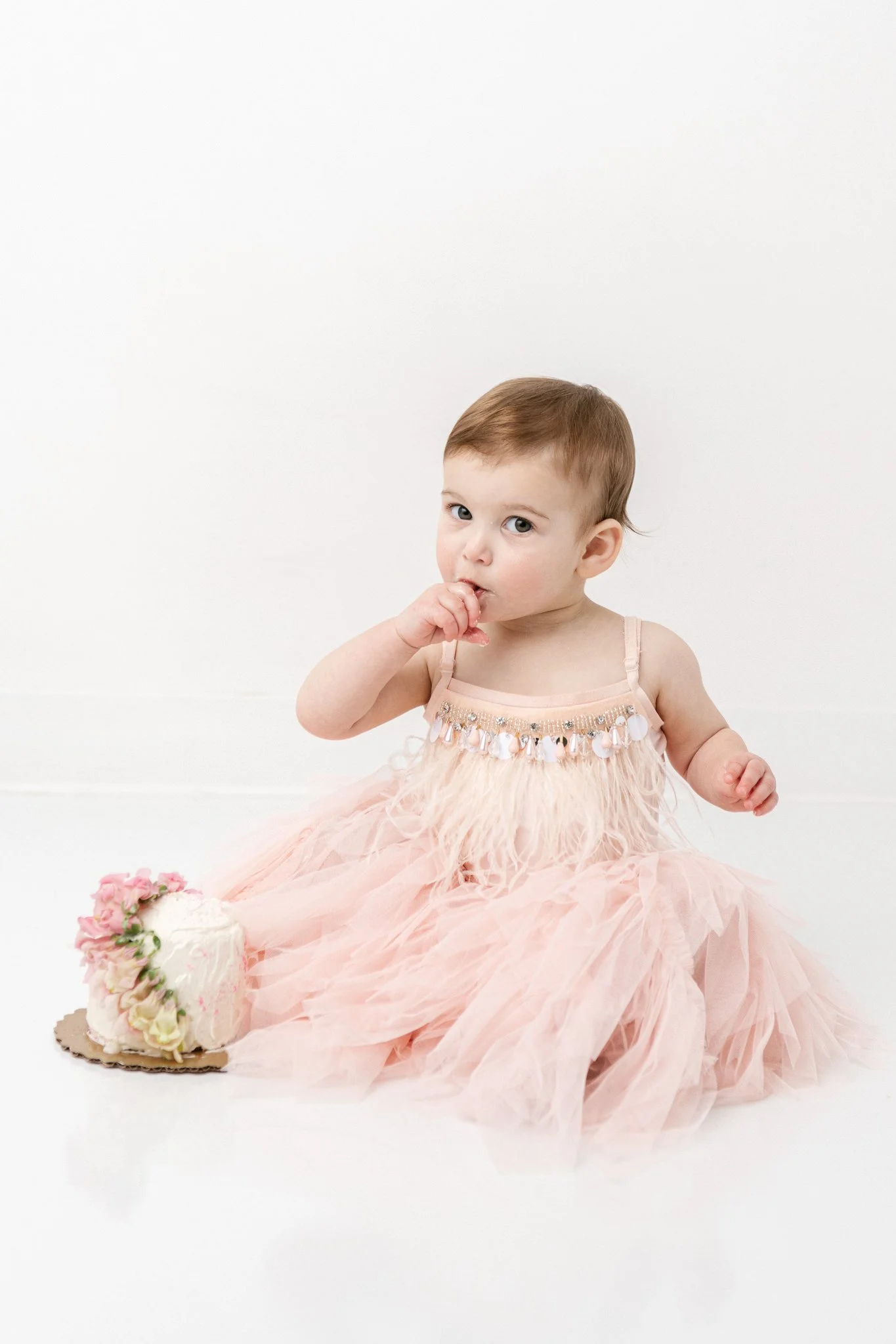  A cake smash session in a studio in New Jersey captured by professional Nicole Hawkins Photography. cake smash tasting the cake baby girl pink cake simple studio #NicoleHawkinsPhotography #NicoleHawkinsBabies&amp;Children #FirstBirthdayPhotography #
