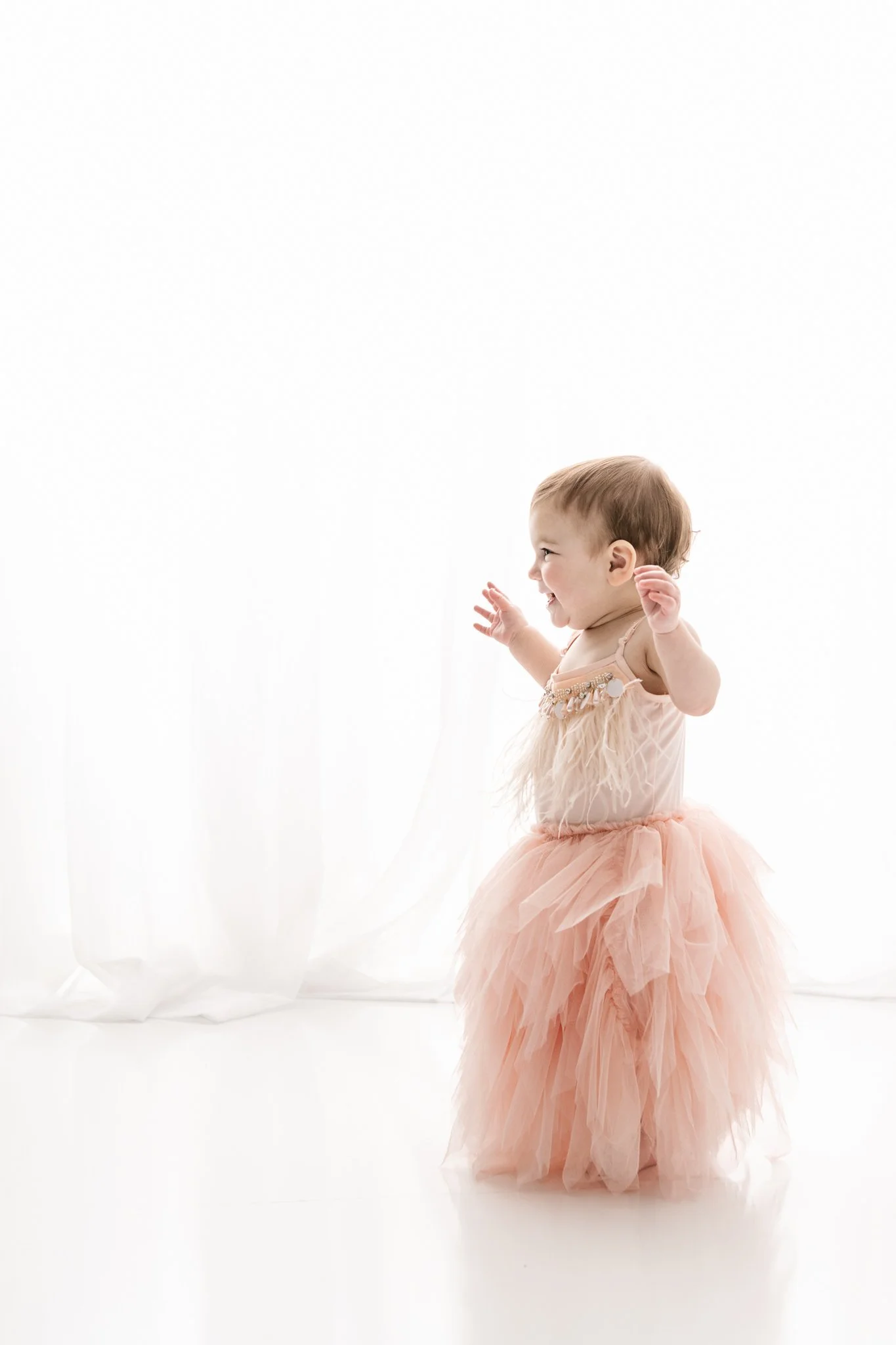  At a New Jersey studio, Nicole Hawkins PHotography captures a little girl walking around in her fluffy pink gown. baby girl style baby walking boho fluffy dress #NicoleHawkinsPhotography #NicoleHawkinsBabies&amp;Children #FirstBirthdayPhotography #S