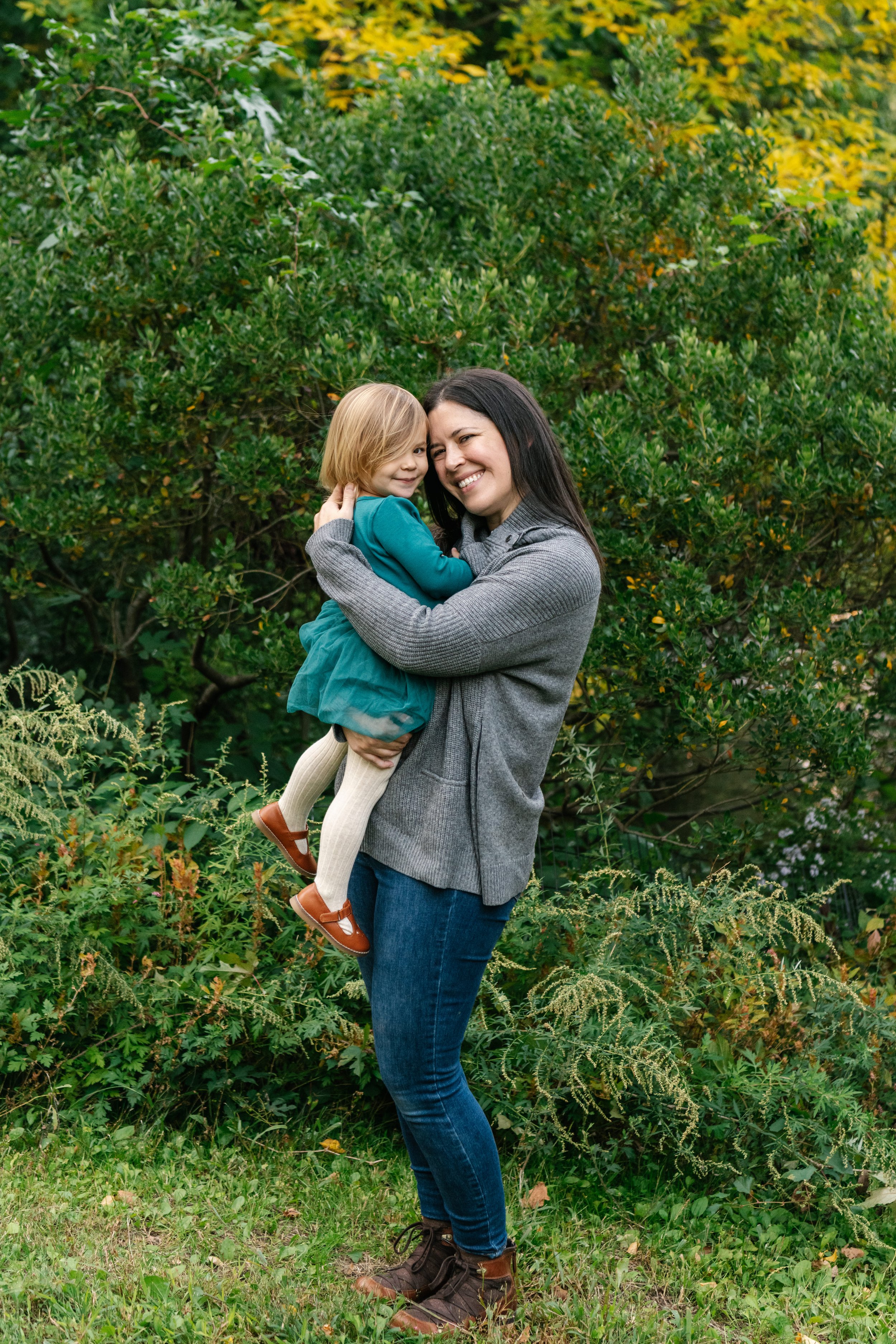  Family Photographer Nicole Hawkins photography captures a mother and child portrait in the middle of Central Park. green dress tights brown shoes jeans and gray shirt style ideas #NicoleHawkinsPhotography #NicoleHawkinsFamilies #NJphotographers #fam