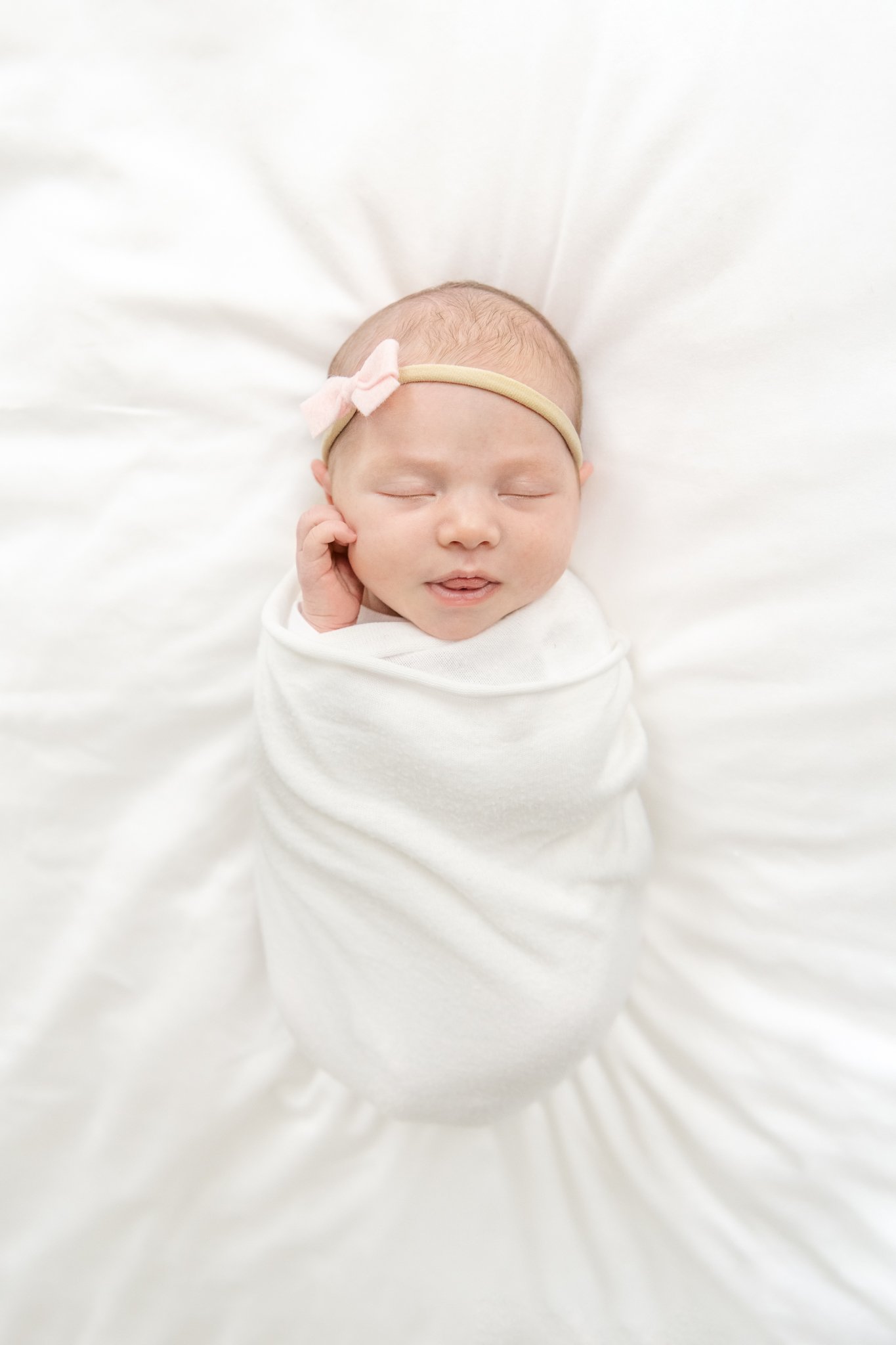  The newborn baby girl portrait was taken during an at-home session with Nicole Hawkins Photography a professional newborn photographer. baby portraits sleeping pink bow swaddle blanket #NicoleHawkinsPhotography #NicoleHawkinsNewborns #Babygirl #Newb
