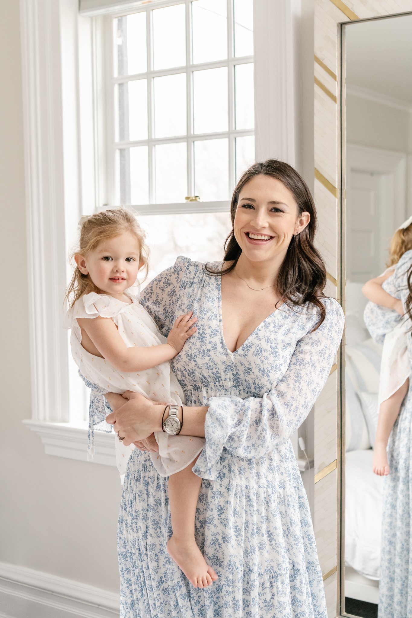  A Mother holds her toddler girl on her hip and smiles during a family newborn session with Nicole Hawkins Photography. mother and child portrait blue postpartum dress postpartum style #NicoleHawkinsPhotography #NicoleHawkinsNewborns #Babygirl #Newbo