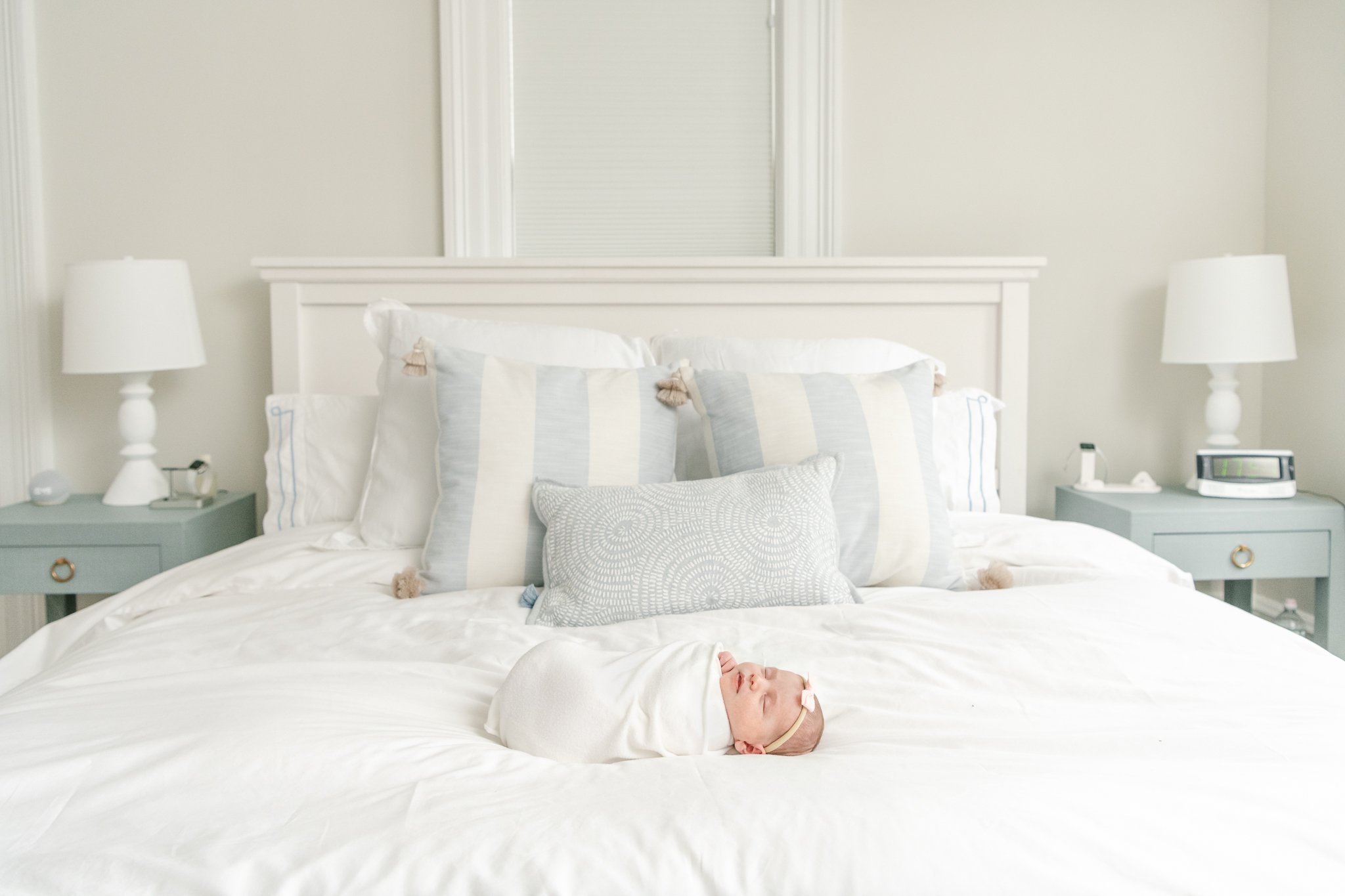  Baby girl swaddled and laying on a white bed and sleeping captured by Nicole Hawkins Photography in MA. newborn photographer in Massachusets #NicoleHawkinsPhotography #NicoleHawkinsNewborns #Babygirl #Newbornfamilyportraits #ChathamNewbornPhotograph