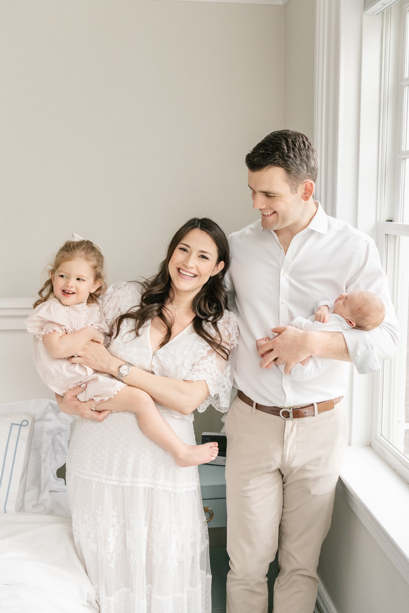  In a home in Chatham, MA a mother and smile while holding their two baby girls by Nicole Hawkins Photography. big sister newborn family portrait new baby girl #NicoleHawkinsPhotography #NicoleHawkinsNewborns #Babygirl #Newbornfamilyportraits #Chatha