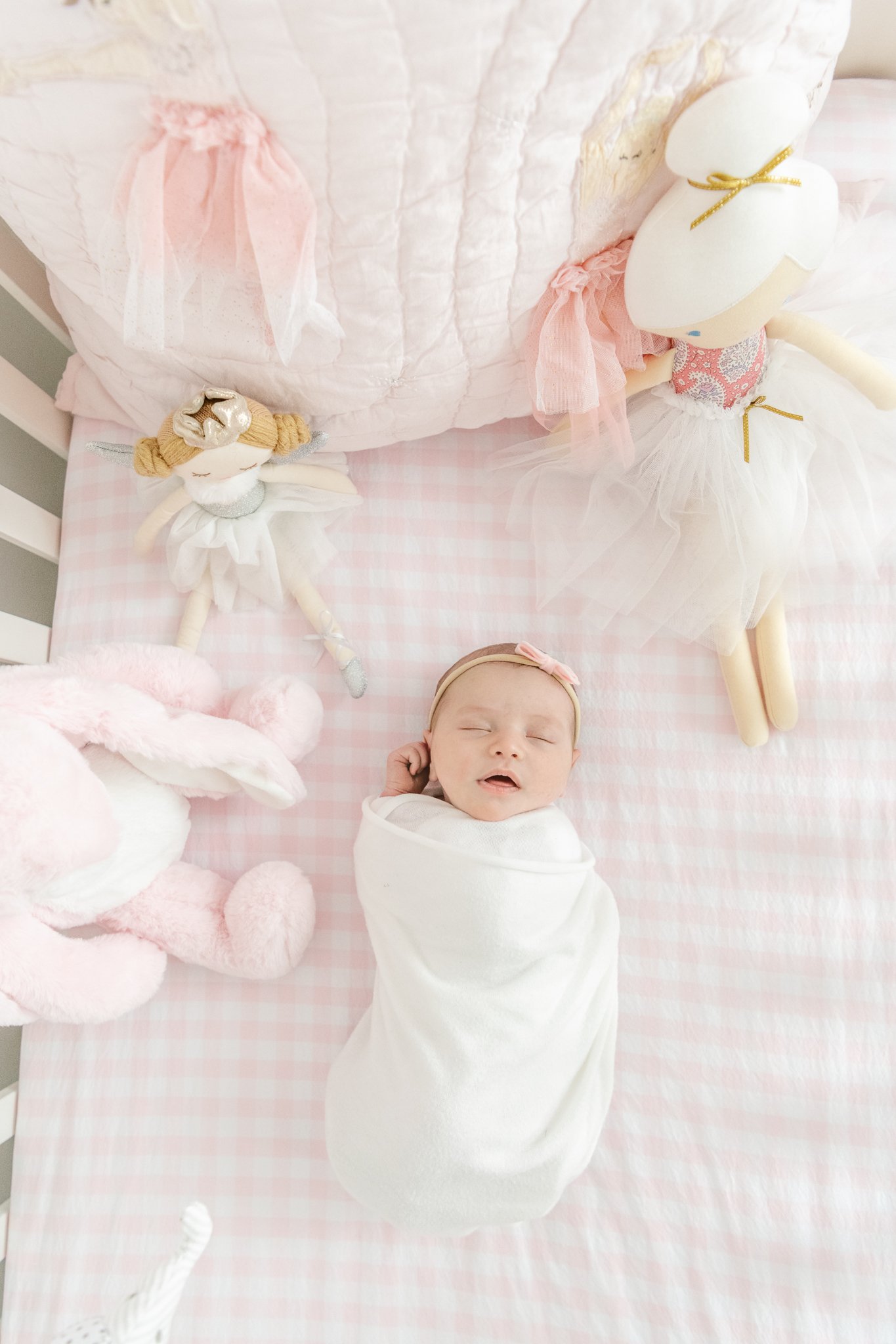  Baby girl in a pink crib with her ballerina dolls by Nicole Hawkins Photography. pink gingham crib ballerina nursery pink crib sheets sleeping baby girl #NicoleHawkinsPhotography #NicoleHawkinsNewborns #Babygirl #Newbornfamilyportraits #ChathamNewbo