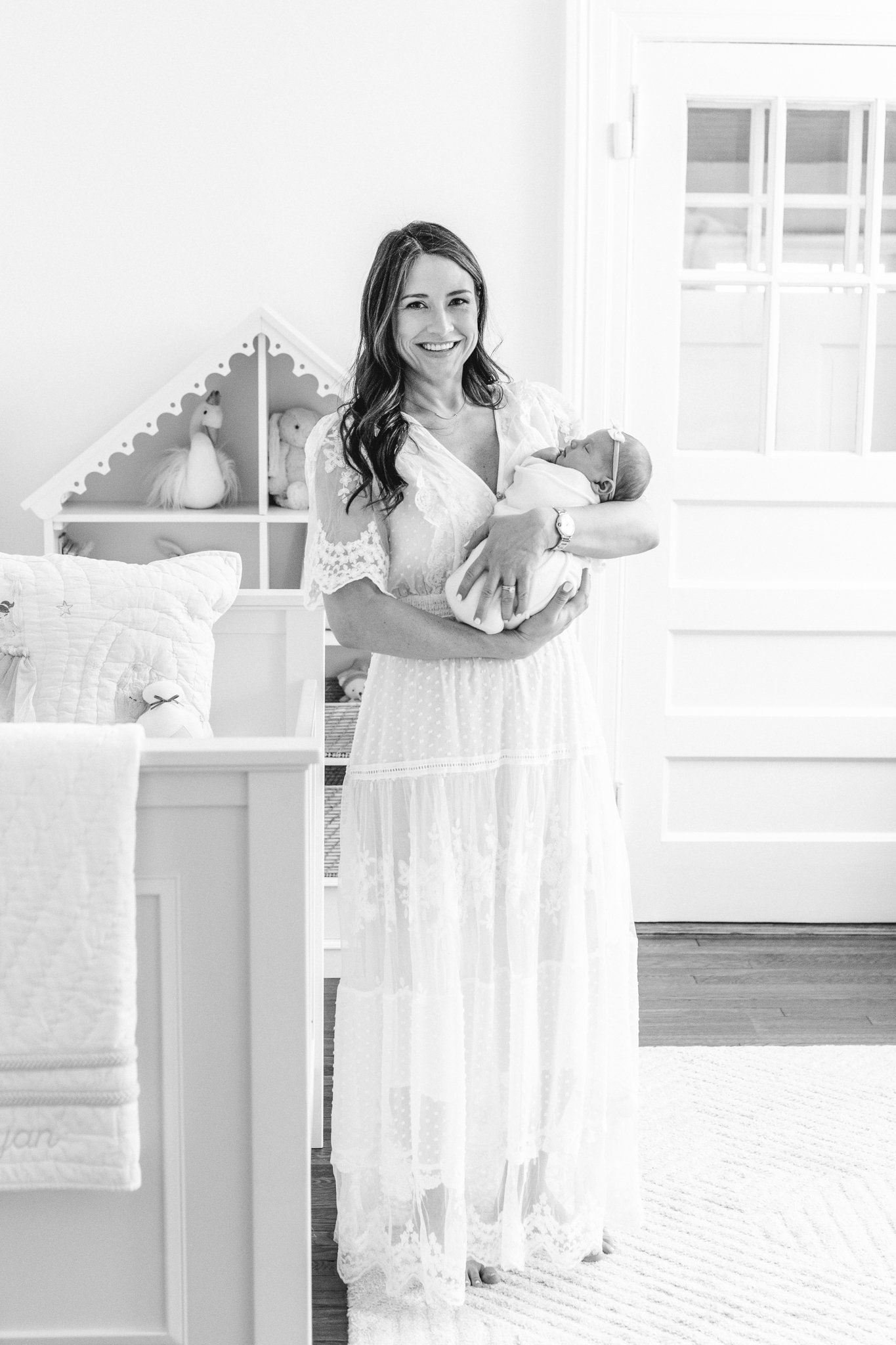  A black and white portrait of a new mother standing in her baby's nursery by Nicole Hawkins Photography. nursery portraits in-home newborn moments #NicoleHawkinsPhotography #NicoleHawkinsNewborns #Babygirl #Newbornfamilyportraits #ChathamNewbornPhot
