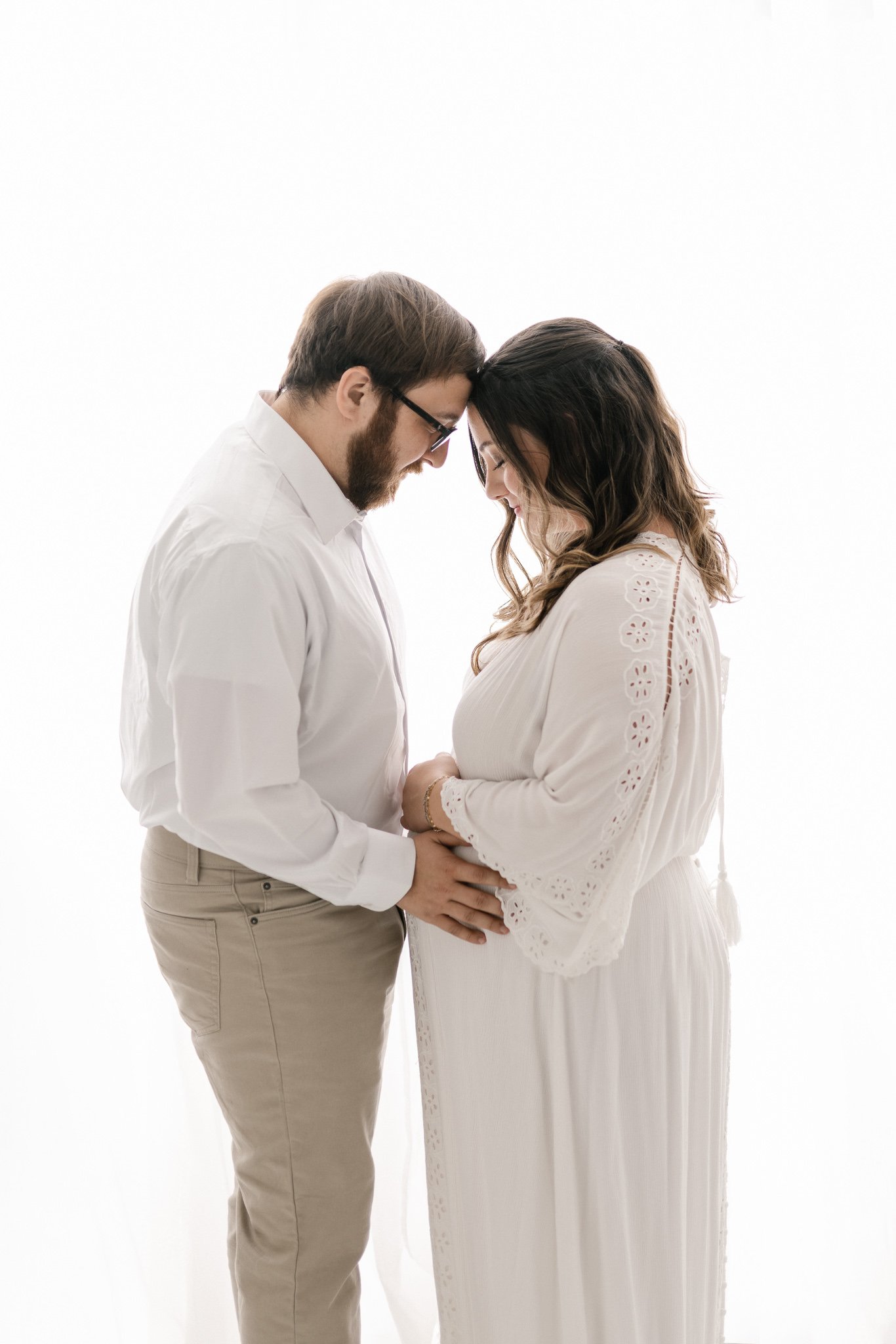  Two parents to be with head together at a white studio in New Jersey by Nicole Hawkins Photography. profile of parents to be new jersey photographers #NicoleHawkinsPhotography #NicoleHawkinsMaternity #Babyontheway #studiomaternityNJ #whitestudiomate