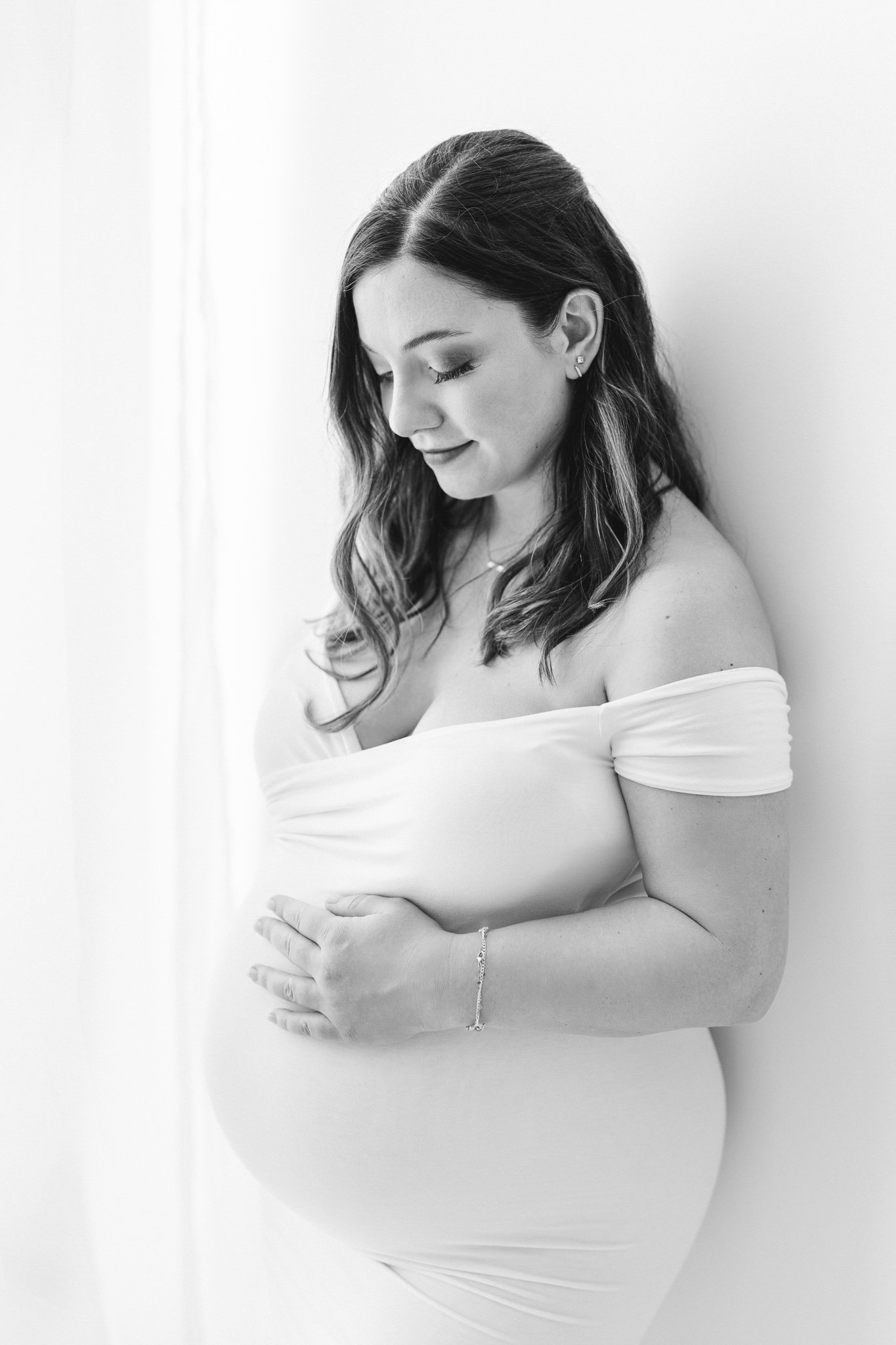  New Jersey Maternity photographer Nicole Hawkins Photography captures a modern studio portrait of a woman in her third trimester. thrid trimester white dress #NicoleHawkinsPhotography #NicoleHawkinsMaternity #Babyontheway #studiomaternityNJ #whitest