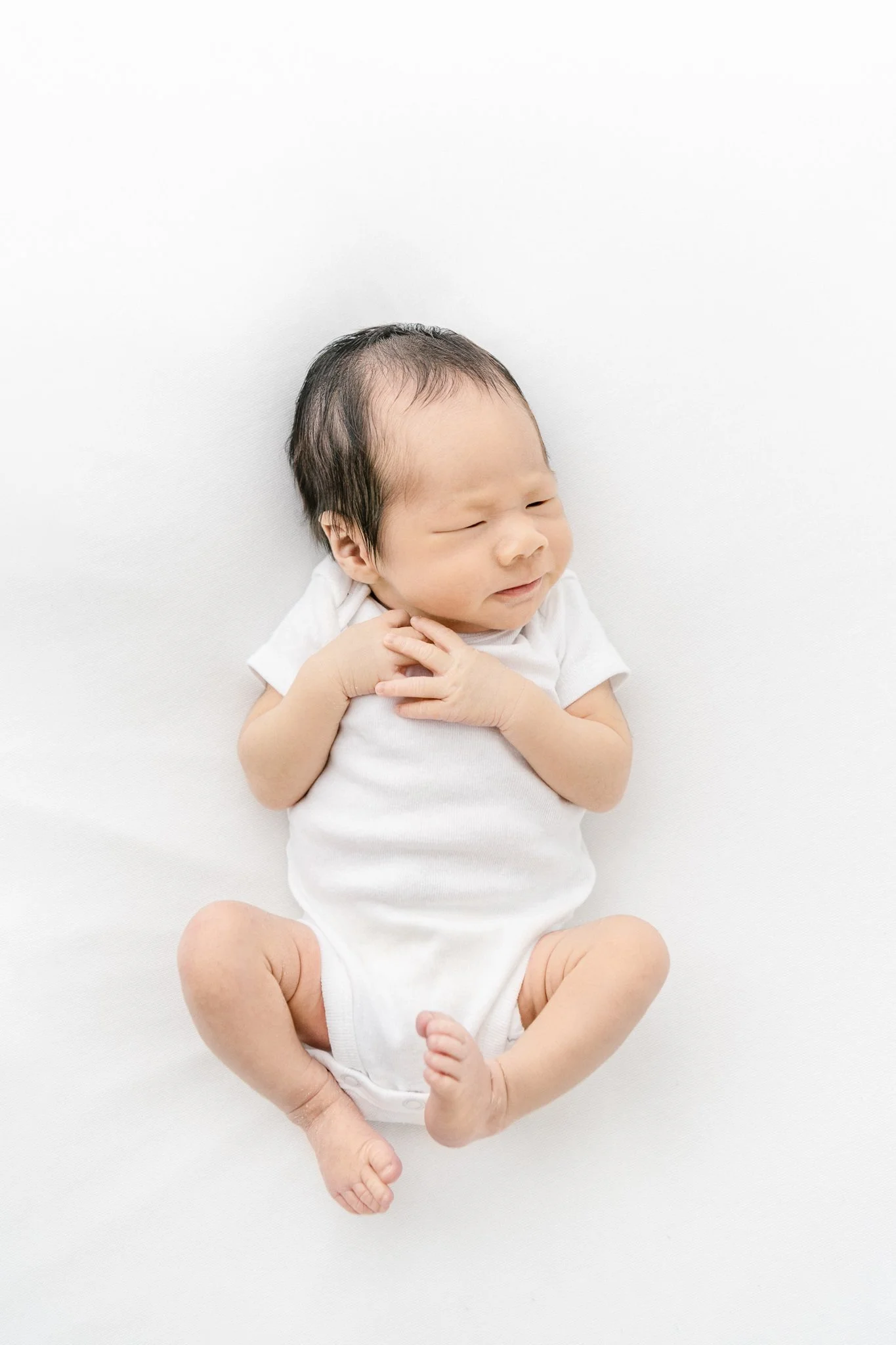  A newborn baby boy with long fingers hugging himself by Nicole Hawkins Photography. baby boy all squished up long finger baby #NicoleHawkinsPhotography #NicoleHawkinsNewborns #Babyboy #studionewbornsNJ #studionewbonportraits #NYnewbornphotographers 