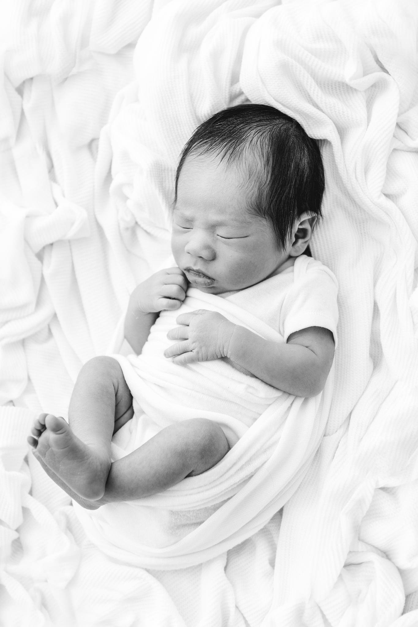  A sleeping newborn baby boy sleeps in a pile of white blanekts captured by Nicole Hawkins Photography. newborn baby boy sleeping Asian newborns #NicoleHawkinsPhotography #NicoleHawkinsNewborns #Babyboy #studionewbornsNJ #studionewbonportraits #NYnew