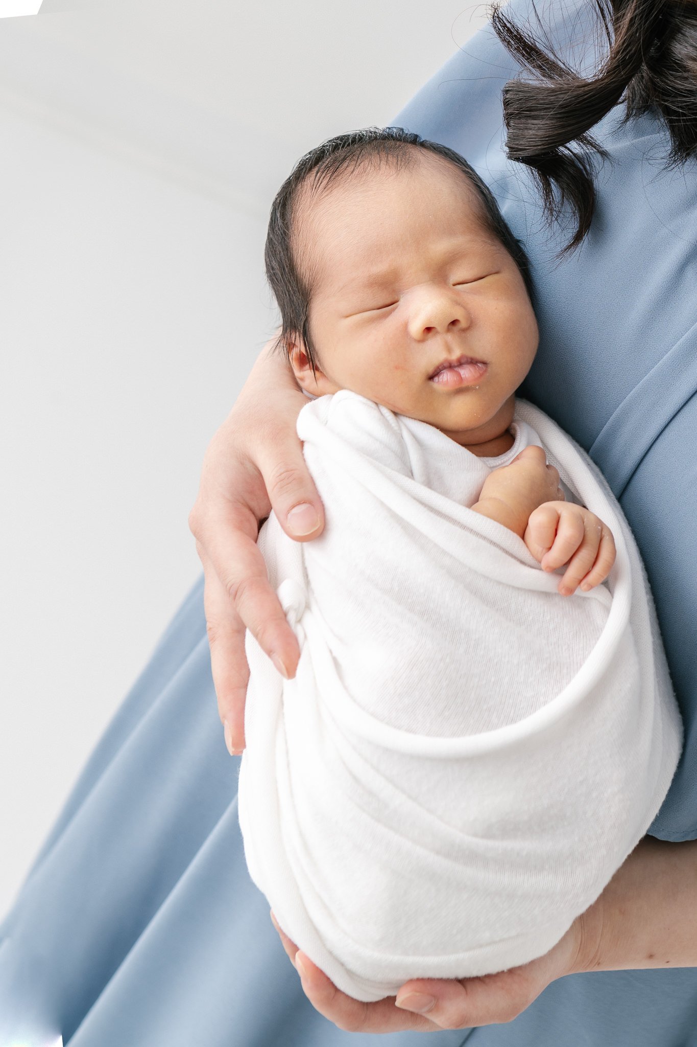  A mother holds her sleeping newborn in her arms during a studio newborn session in NJ with Nicole Hawkins Photography. sleeping baby boy newborn mother and baby #NicoleHawkinsPhotography #NicoleHawkinsNewborns #Babyboy #studionewbornsNJ #studionewbo