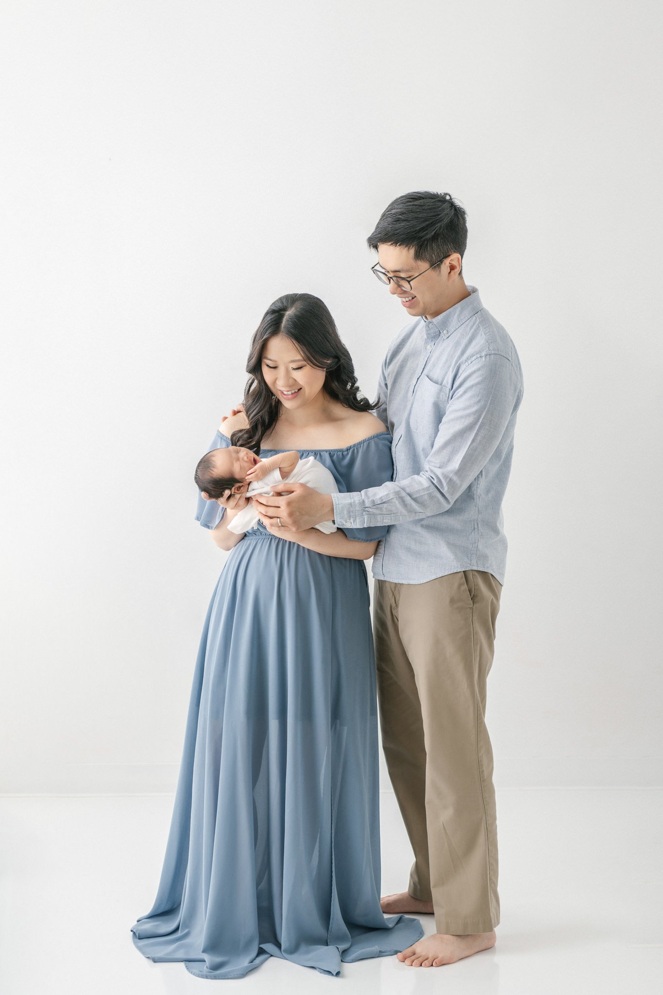  A mother and father look lovingly down at their newborn baby boy by Nicole Hawkins Photography. family portrait studio family New Jersey high-end #NicoleHawkinsPhotography #NicoleHawkinsNewborns #Babyboy #studionewbornsNJ #studionewbonportraits #NYn