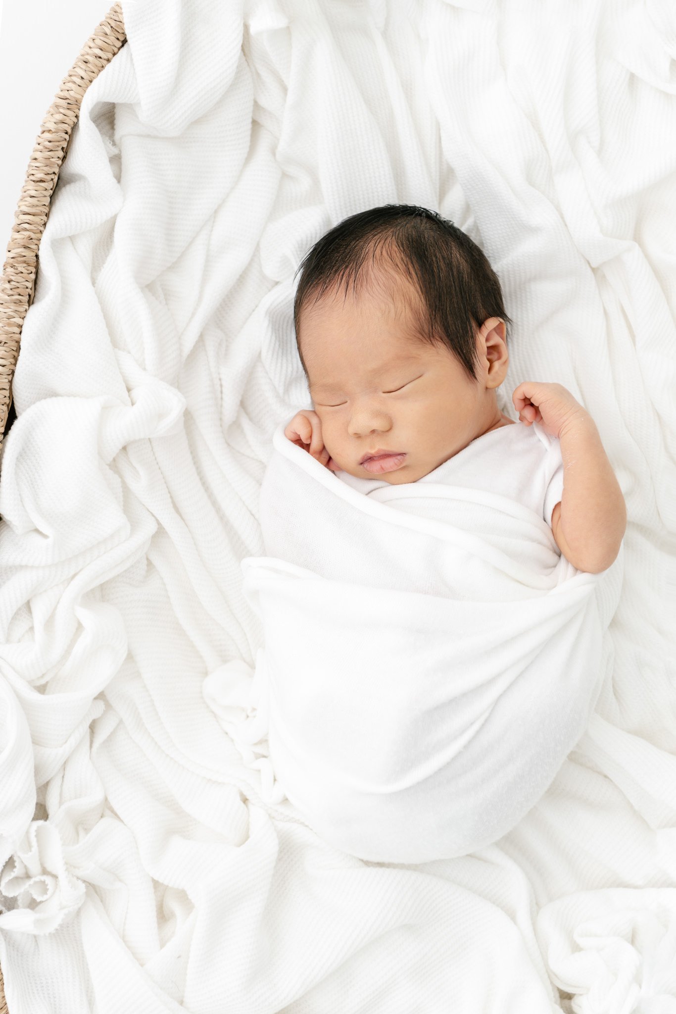  Sleeping baby boy in a wicker bassinet at a studio in New York by Nicole Hawkins Photography. baby in wicker bassinet portrait of baby boy #NicoleHawkinsPhotography #NicoleHawkinsNewborns #Babyboy #studionewbornsNJ #studionewbonportraits #NYnewbornp